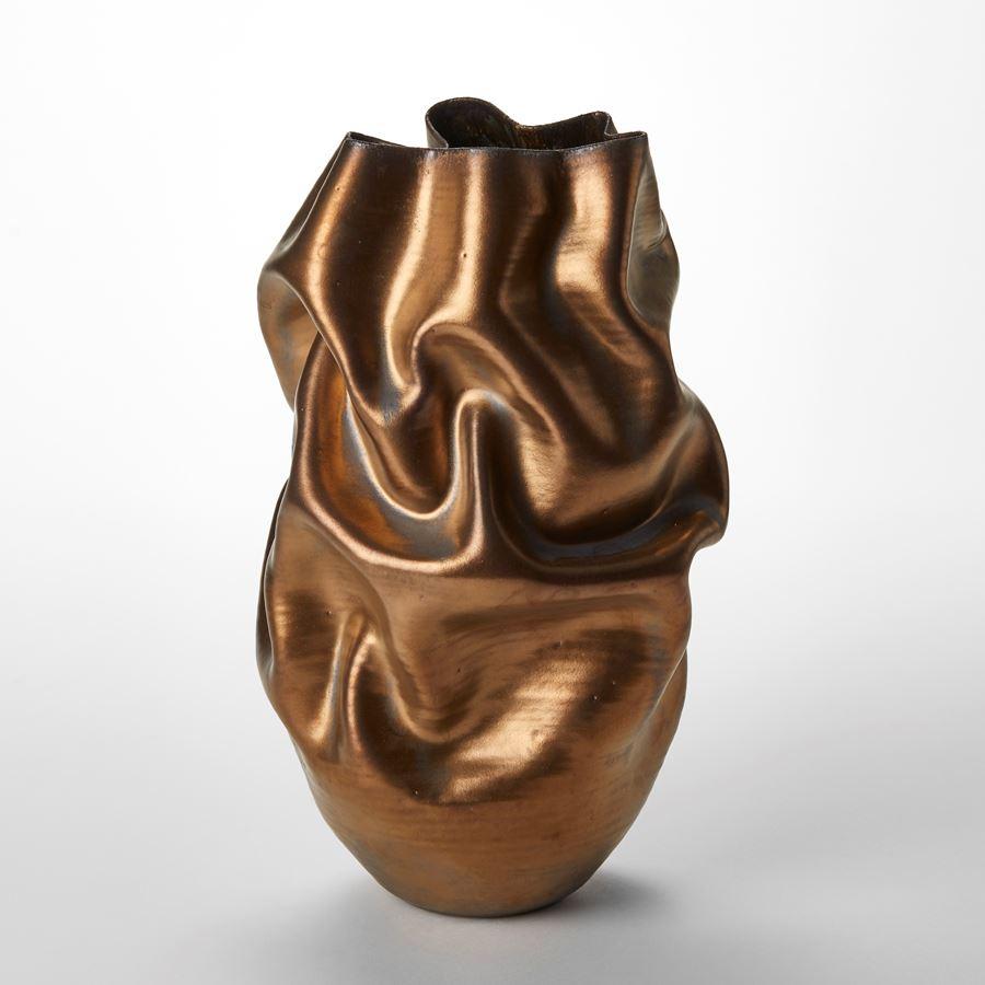 'Tall Gold Crumpled Form No 131' è un vaso scultura unico dell'artista britannico Nicholas Arroyave-Portela.

La pratica professionale della ceramica di Nicholas Arroyave-Portela è iniziata nel 1994. Dopo 20 anni di permanenza a Londra, si è