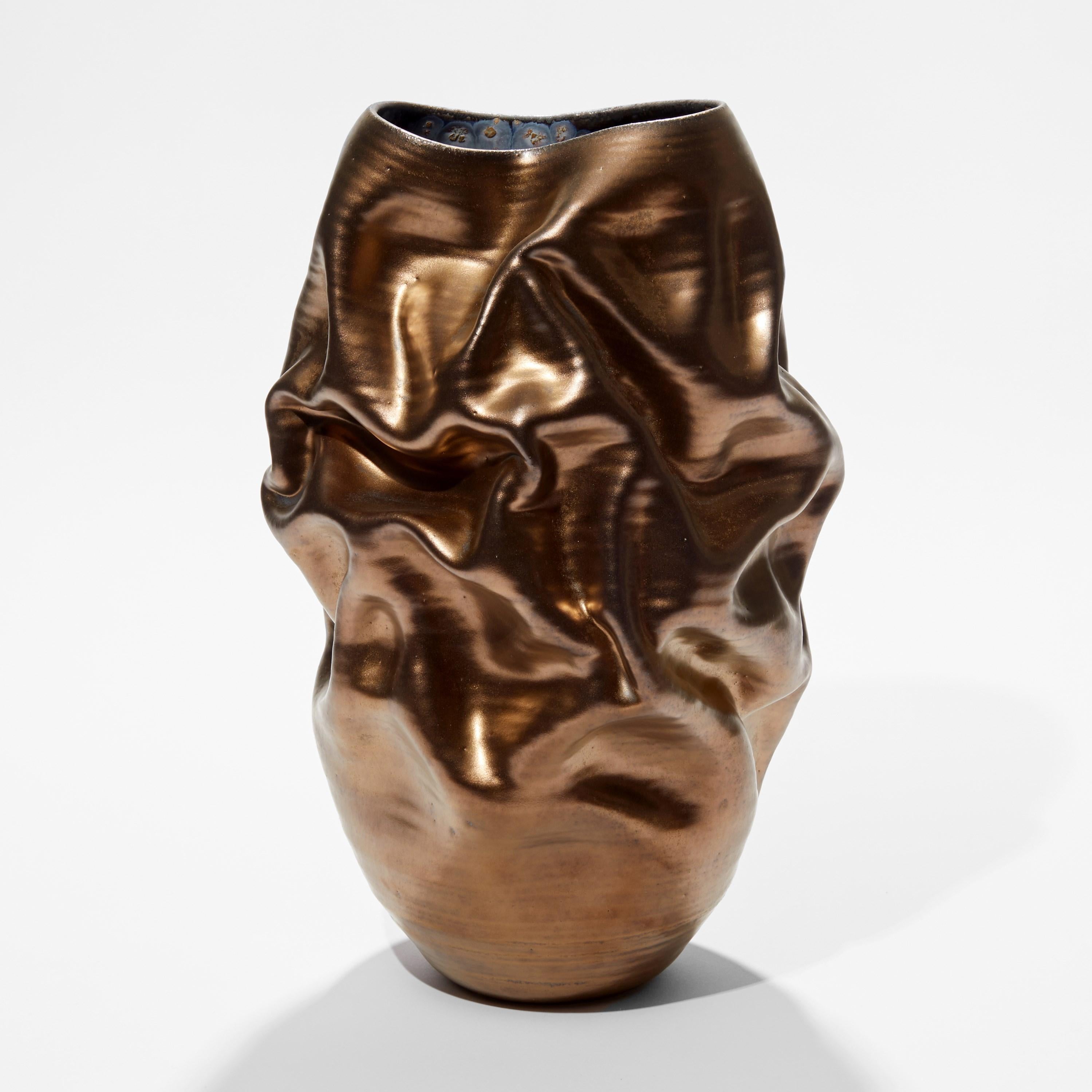‘Tall Gold Crumpled Form No 96’ is a unique sculptural vessel by the British artist, Nicholas Arroyave-Portela.

Nicholas Arroyave-Portela’s professional ceramic practise began in 1994. After 20 years based in London, he moved and set up his