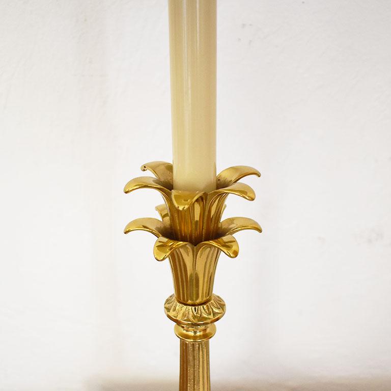 A tall petite table lamp that would be fabulous on a small reading table. The body is created from golden brass and is decorated with leaves that outstretch to look like petals. The base has four claw feet, and the cord has a rotary switch.