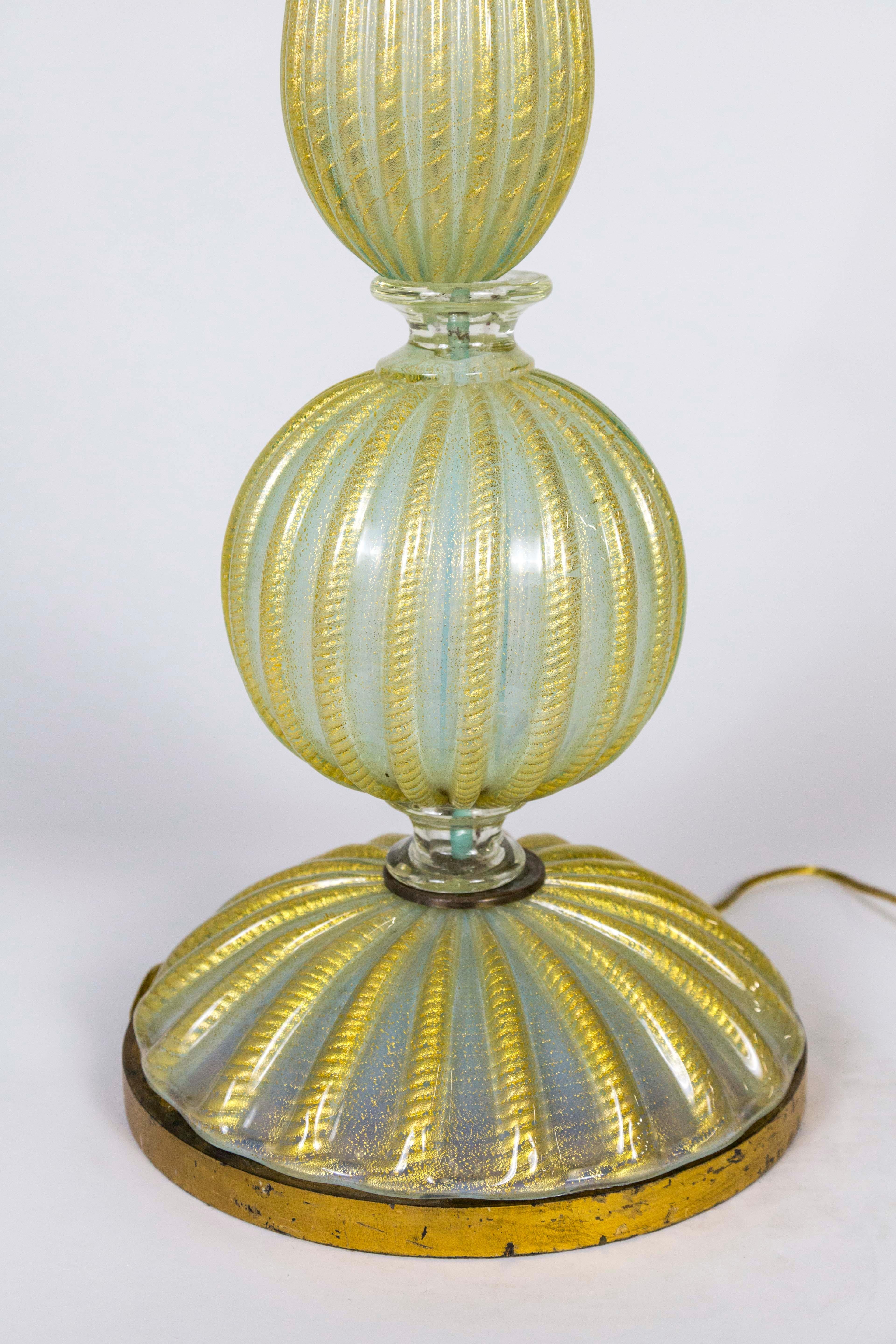 A tall, ribbed, baluster shaped, Venetian glass lamp, in striped yellow and milky, pale blue-green, with a gilded base, 1930s, Italy. Newly rewired. Measures: 38.75