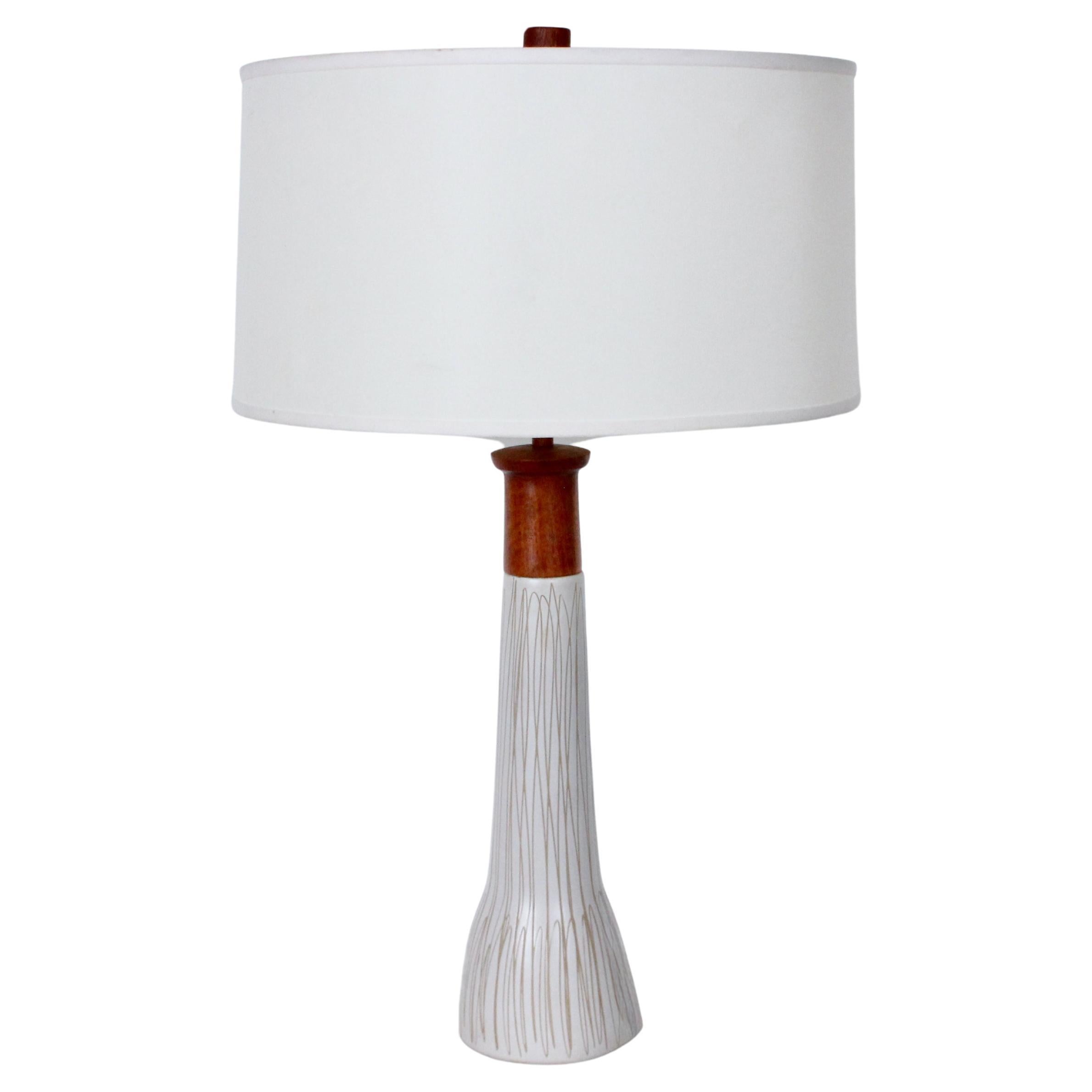 High Jane and Gordon Martz for Marshall Studios Ceramic & Teak table lamp. Featuring model M165-28-1 matte glazed Off White Stoneware form with Clay exposed hand incised detail, Teak stem, neck, cap and original finial. Shade for Display only (11H x