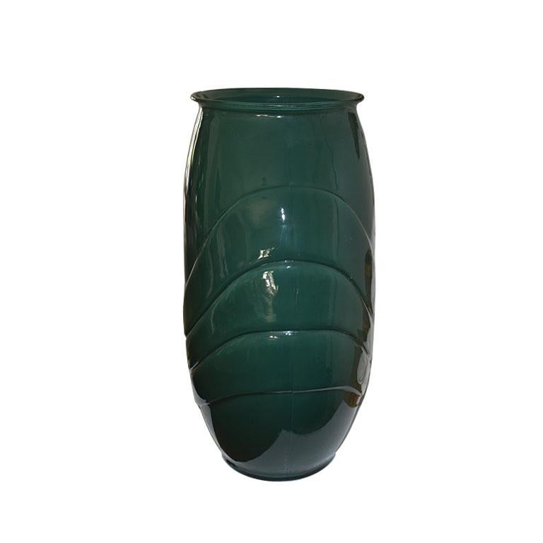 A beautiful tall glass Art Deco style vase. This large vessel is in deep emerald green and features a swooping raised design across the front on both sides. 

Dimensions:
16