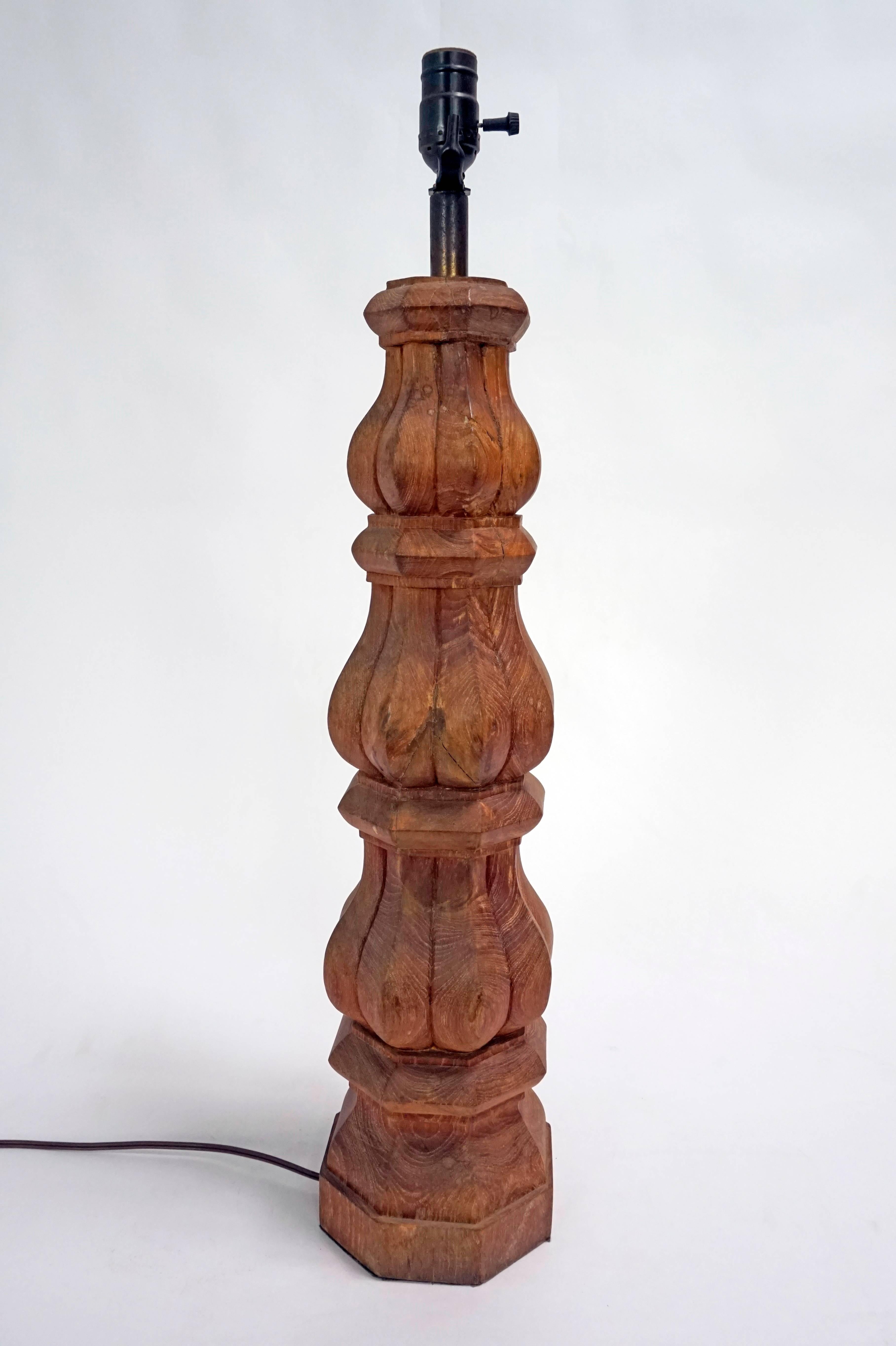 A large, balustrade, hand carved, redwood table lamp, dark-tinted, brass neck. Dimmer switch on brown cord. Recently rewired. Measures: 28.5