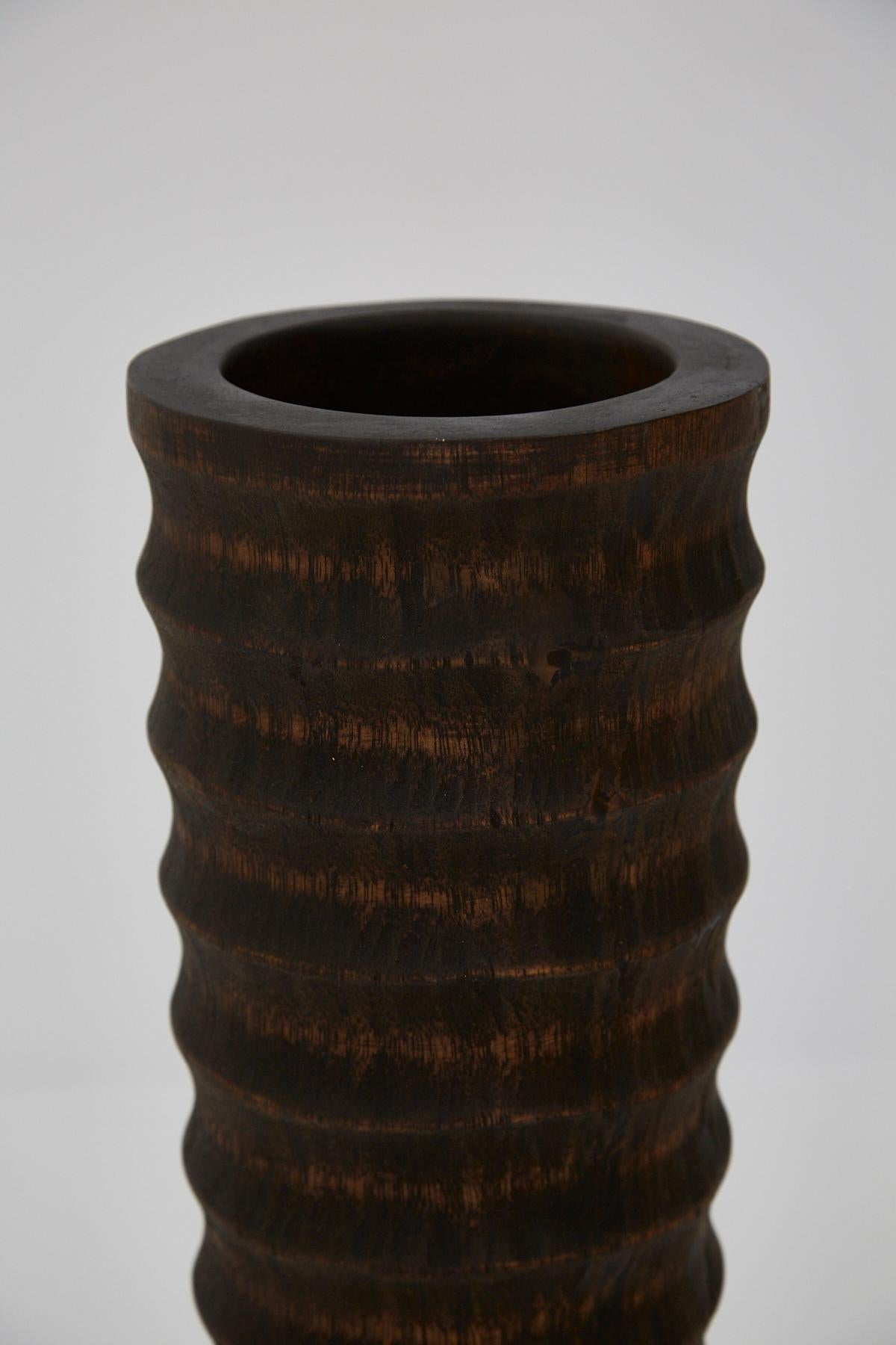 Tall 36 in. hand carved horizontally ribbed wooden floor vase with dark finish. Well for plants measures approx. 8 in. deep and a plastic liner is included.
