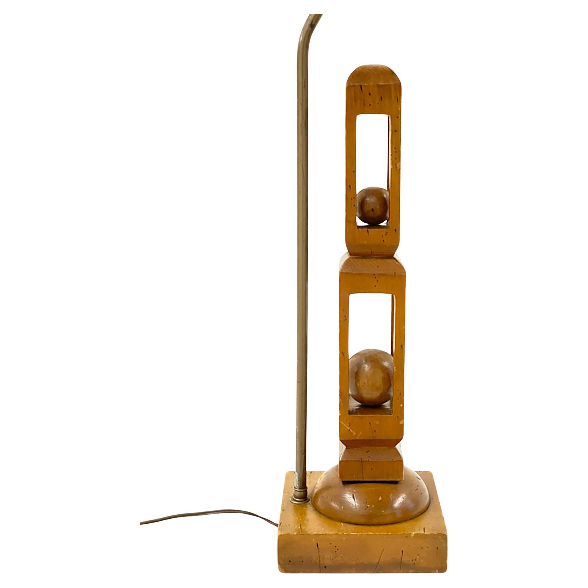 Lampada alta in legno intagliato a mano con sfera d
arte popolare in gabbia, che fa pensare a qualcosa di strano.