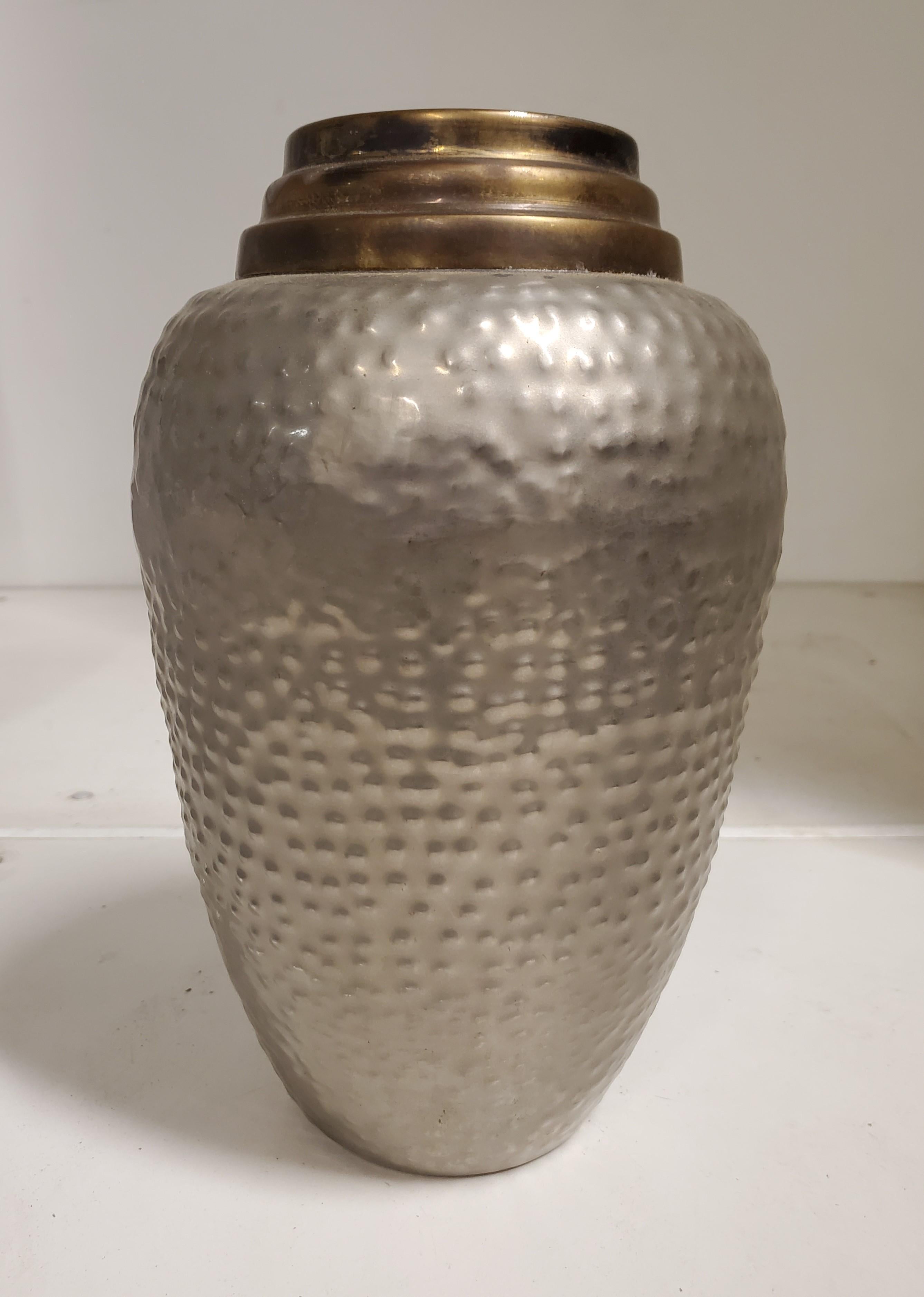 A two tone, hand hammered brass vase with a satin nickel /pewter and antique brass finish. 
This brass vase features lovely metalwork with a protruding stippled, dew drop, polka dot design and a ribbed linear neck. 
 Depicting a studded, textured,