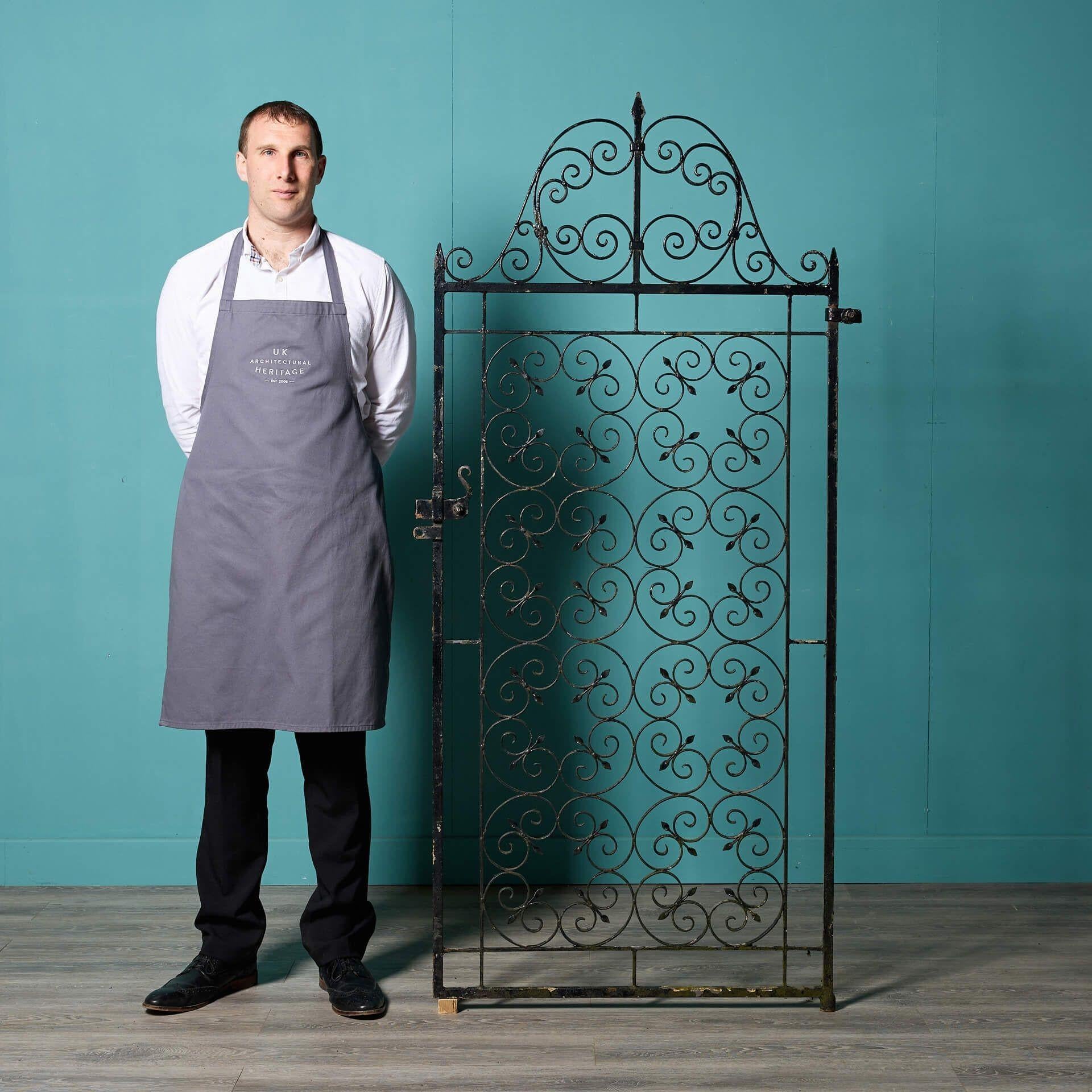 A stunning tall garden gate, handcrafted by a talented early 20th century blacksmith and reclaimed from a property in Surrey. Standing at 1.8m tall, this wrought iron gate is perfect for the side of a house or a narrow courtyard, the elaborate