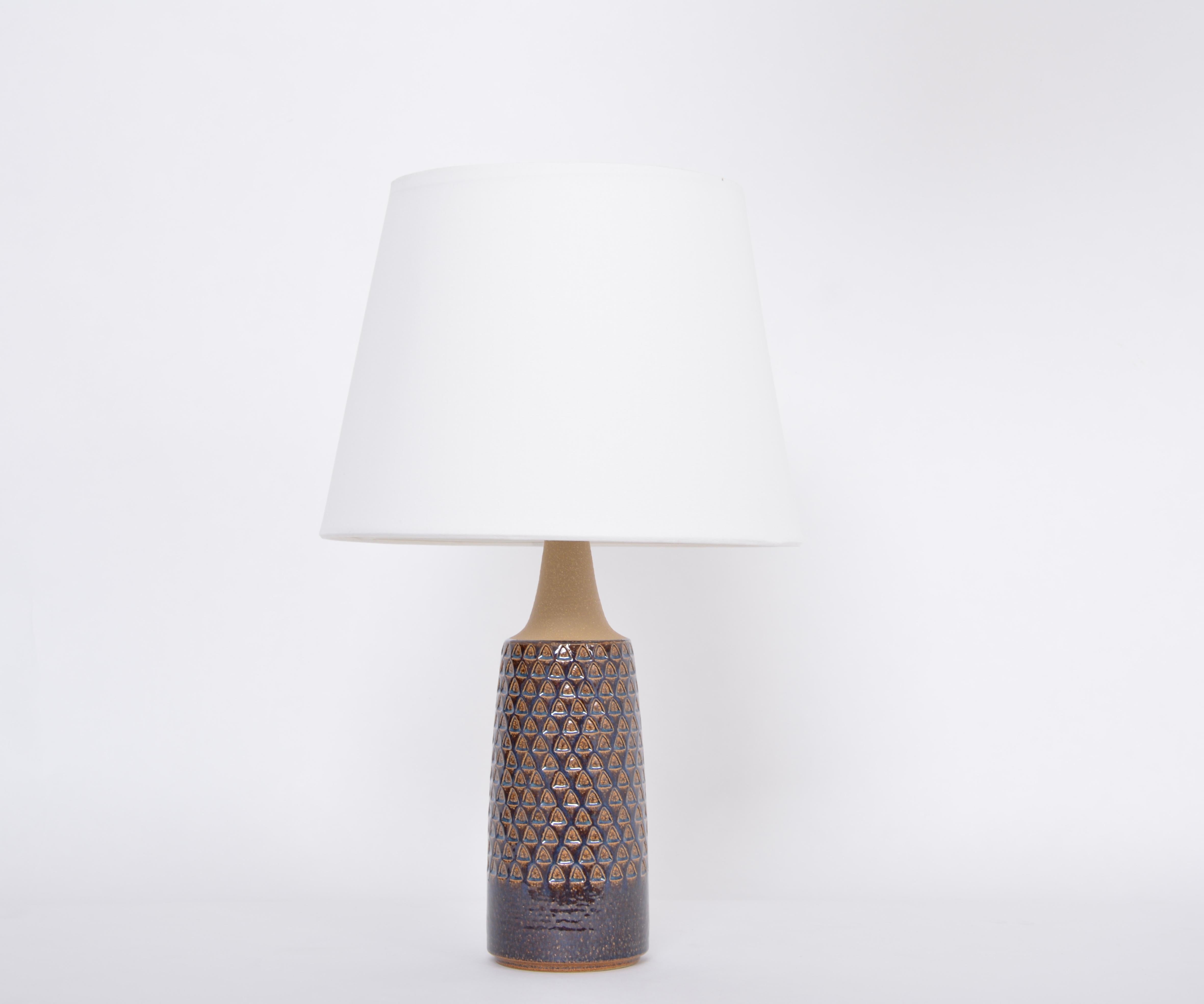 Tall Handmade Danish Mid-Century Modern Ceramic table lamp by Soholm
This table lamp was produced by Soholm Stentoj in Denmark in the 1960s. Gorgeous glazing in different colors ranging from brown to dark blue. The base features a graphic relief