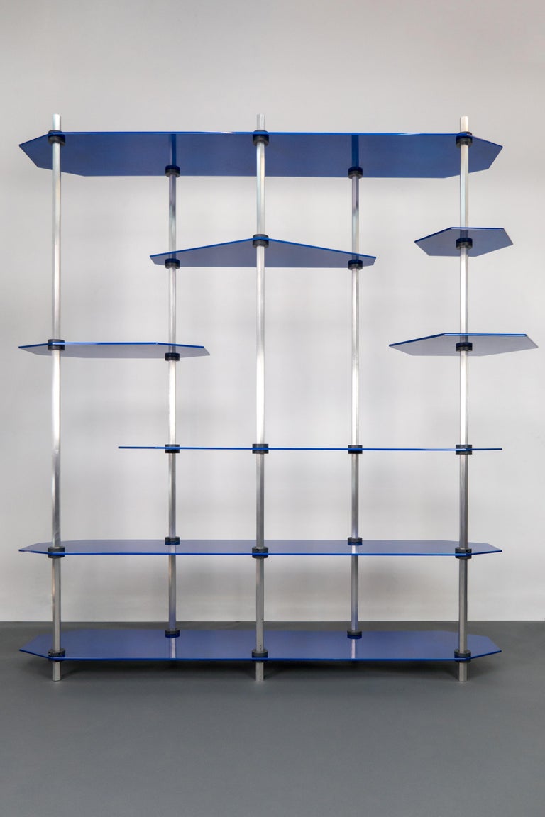 Modular shelving or storage unit with adjustable height shelves and customizable shapes and colors. For use as a bookshelf or display shelving or entertainment / media centre. Custom color options are available. Shown in a metallic blue glaze with