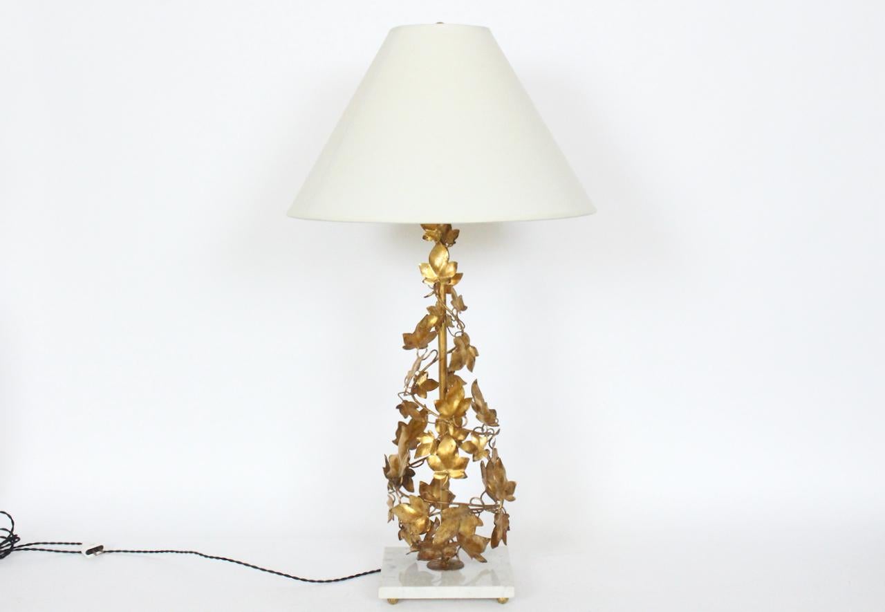 Substantial Italian Mid-Century Modern Venetian Tole Gilt Wire table lamp.
Featuring a hand crafted tall open wire form with three dimensional gilded Ivy leaf like decoration throughout a top a square 8.25W x .75H White Carrara Marble base and four