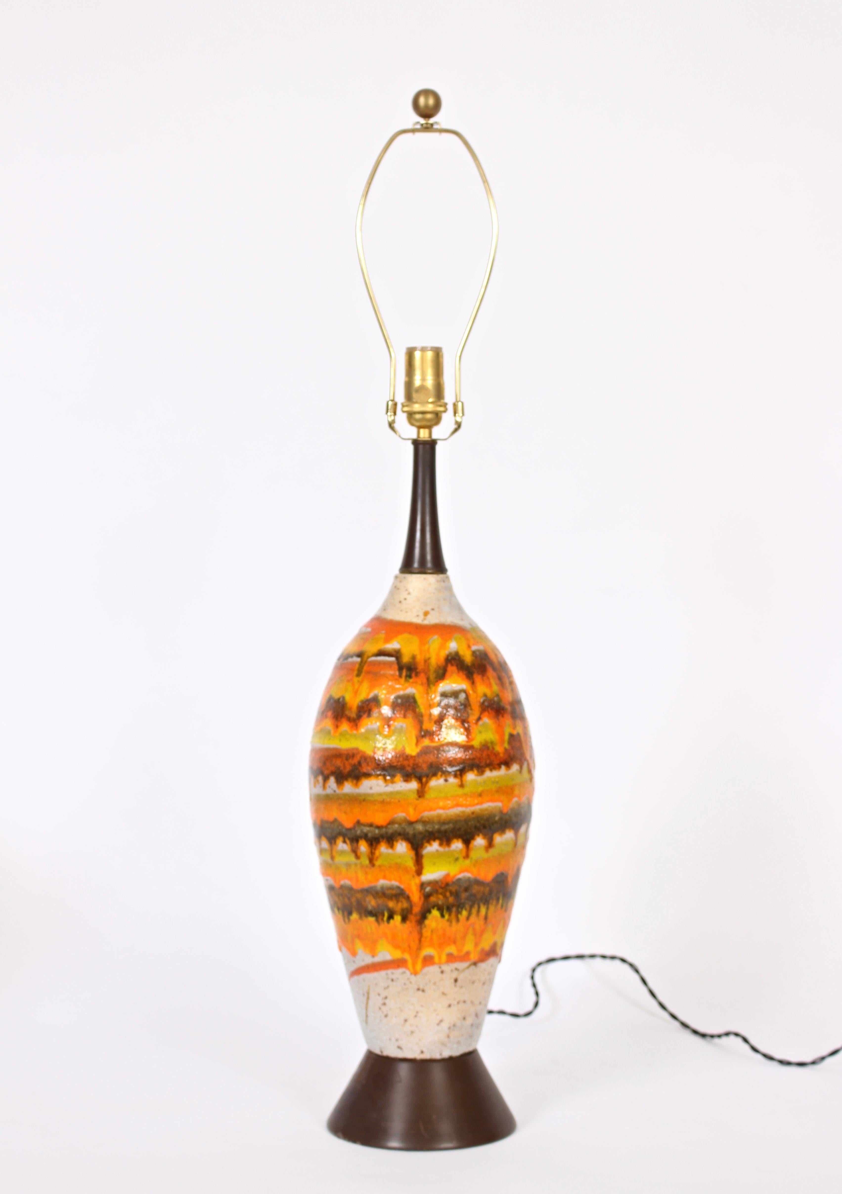 Substantial European crafted glazed ceramic table lamp, 1950's.  Featuring a slender bottle form, vibrant lava banding, drip glazes, hand painted salt and pepper enhanced natural toned base with orange, gold, mustard, coffee, and chocolate