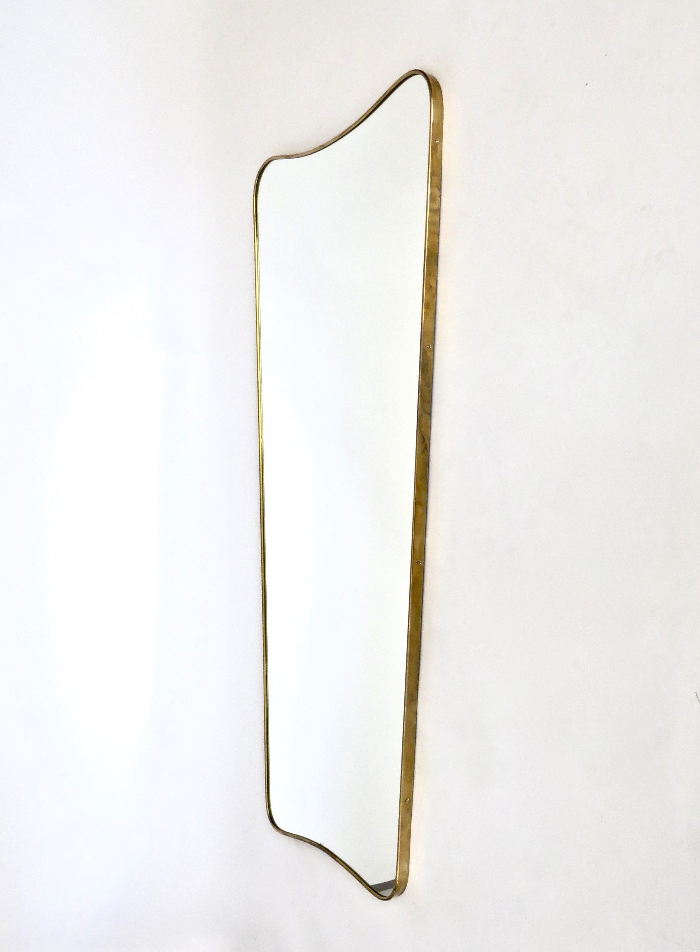 Elegant vintage wall mirror with deep solid brass frame and mirror glass. Made in Italy in the 1940s-1950s, original and not a reproduction.
The brass frame has a very nice patina and may be polished if desired.
At the back the mirror is