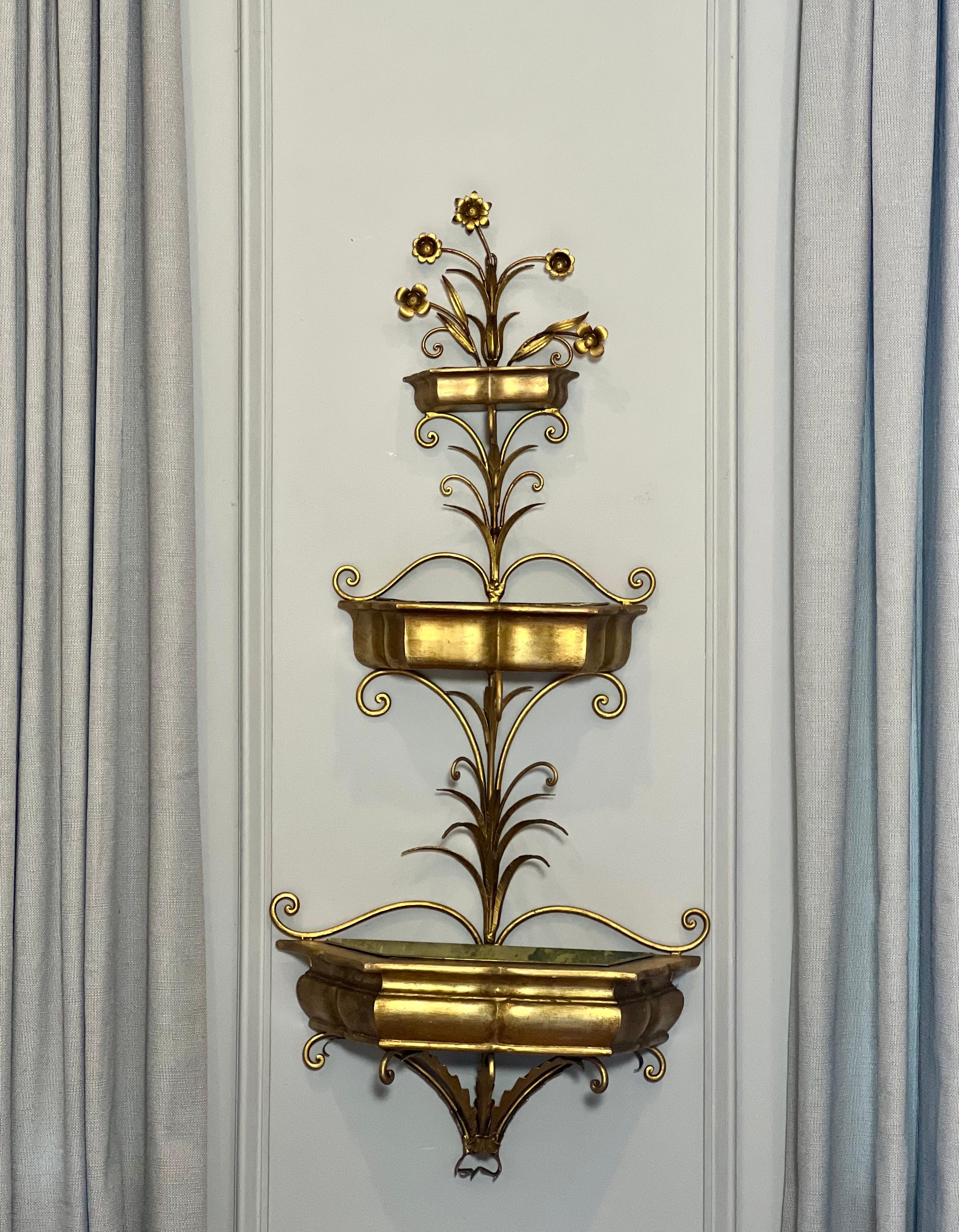 Jardinière suspendue à trois niveaux en bois doré et en fer forgé de l'époque Hollywood Regency. Il présente trois niveaux gradués avec des jardinières en bois doré, soutenues par un cadre en fer forgé doré avec des volutes et des feuilles sous un