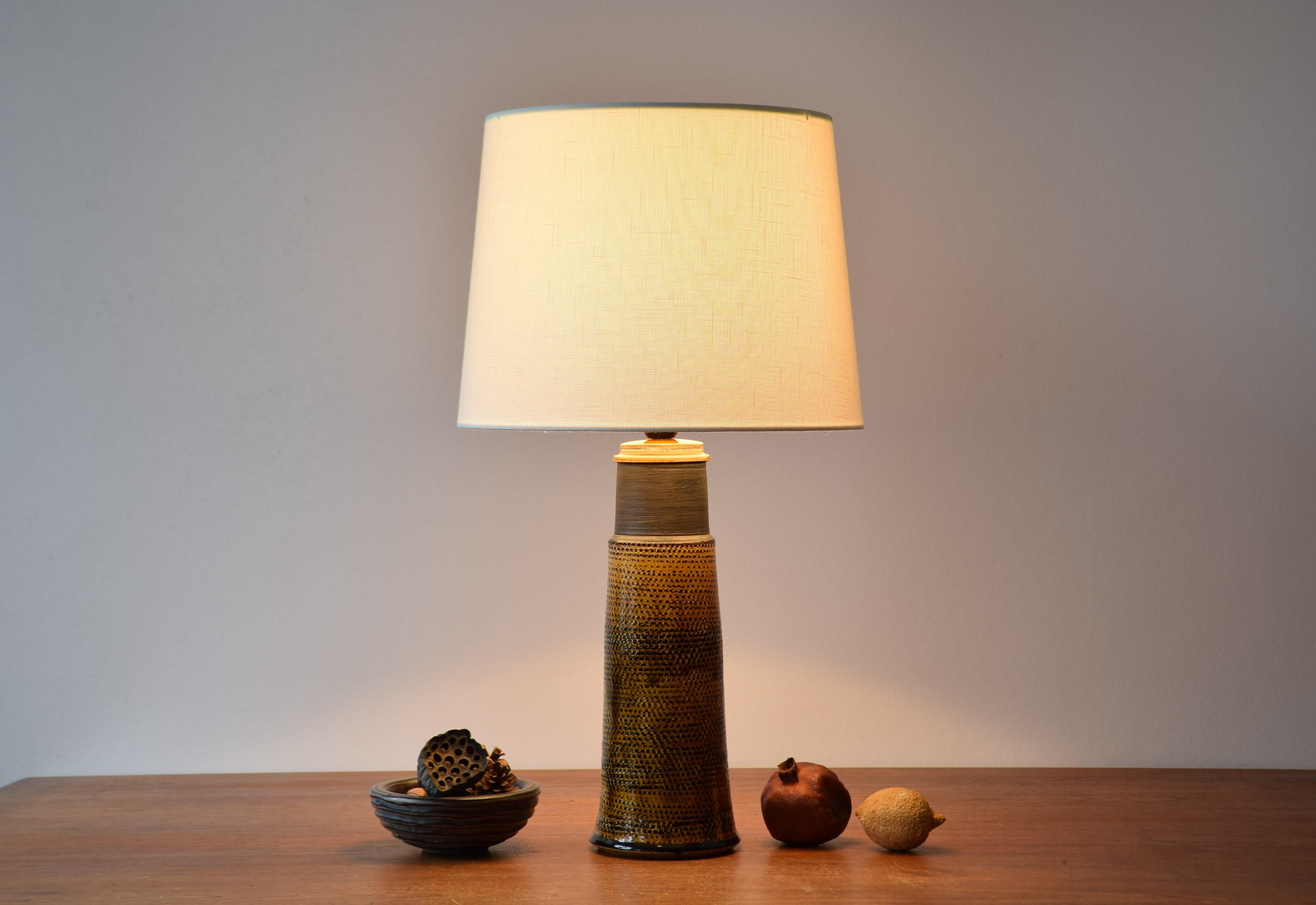 Tall table lamp from Herman A. Kähler´s (HAK) ceramic workshop in Denmark, made ca 1960´s. The design is most likely by Nils Kähler.

Nils Kähler (1906-1979) was fourth generation of the family Kähler. He and his brother Herman Jørgen Kähler, who