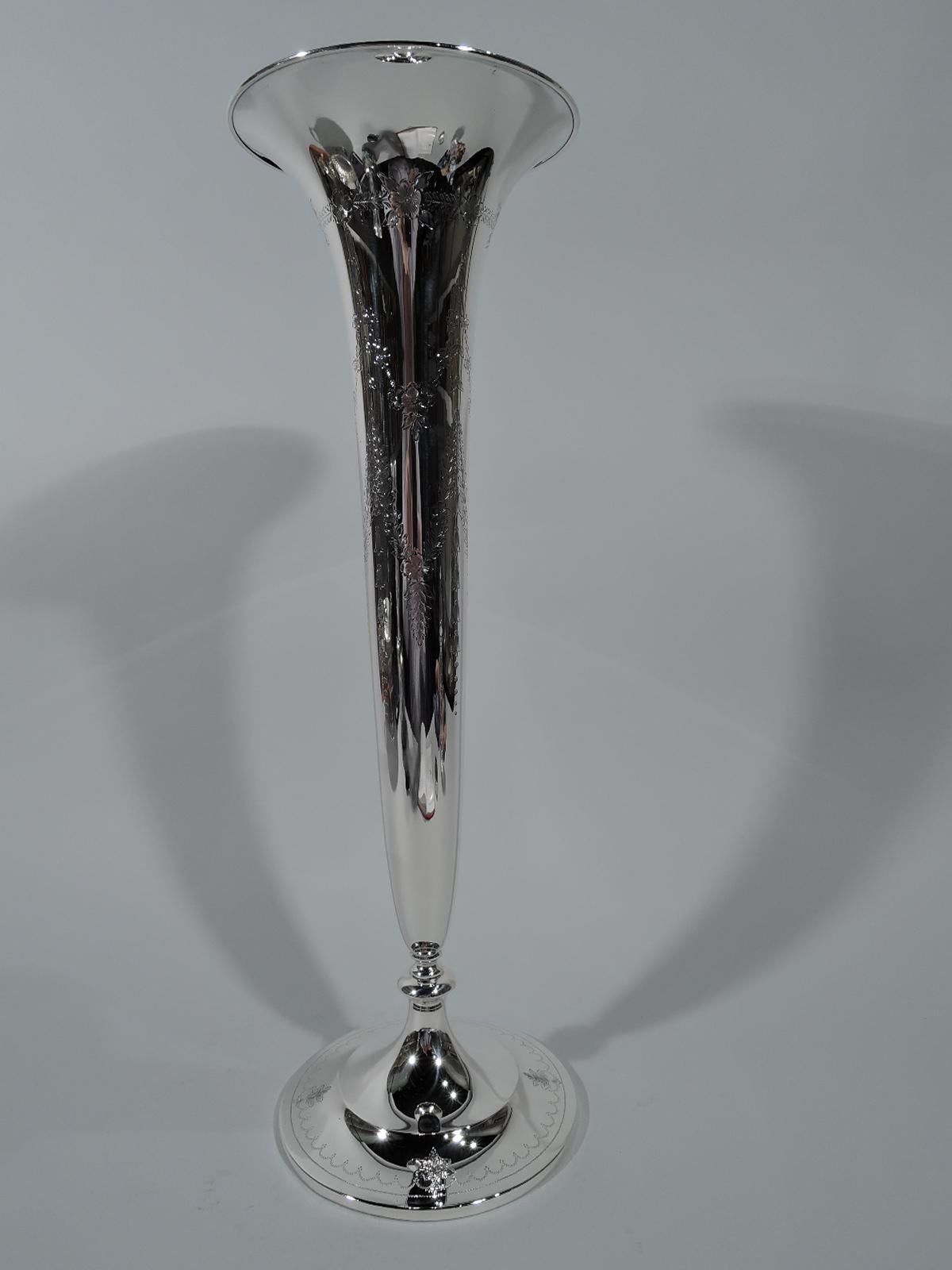 Edwardian sterling silver trumpet vase. Made by S. Kirk & Son Co. Tall, narrow and tapering with flared rim on knop on double-domed foot. Engraved pendant garlands forming frames (vacant). Foot has engraved scalloped border interspersed with leaves.