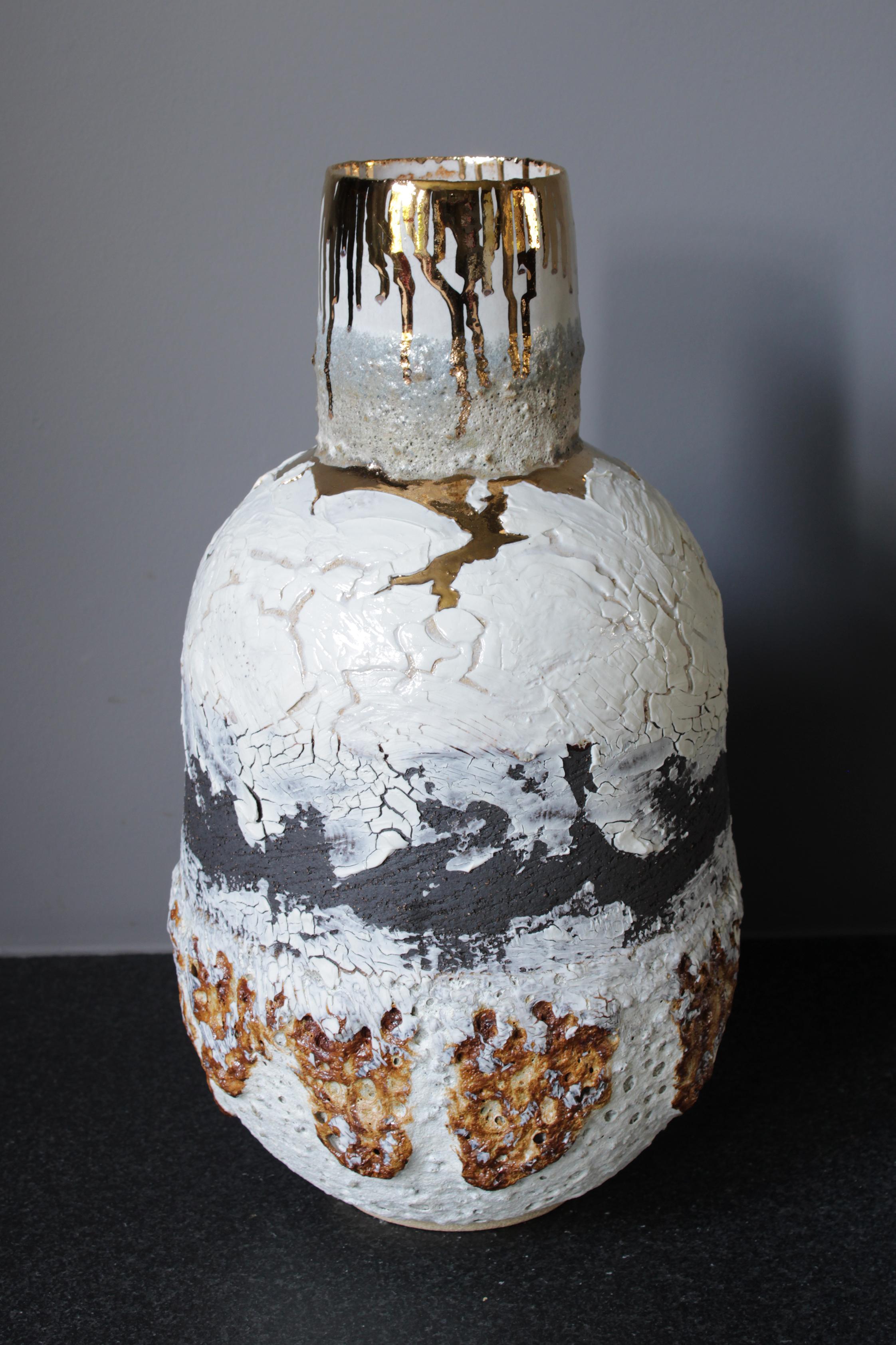Tall large bottle shaped white and black stoneware clay and porcelain vessel with heavy volcanic textured glaze and lava stone.
There is an option to add gold lustre or black feathered glaze to the piece.

The work is hand built using a