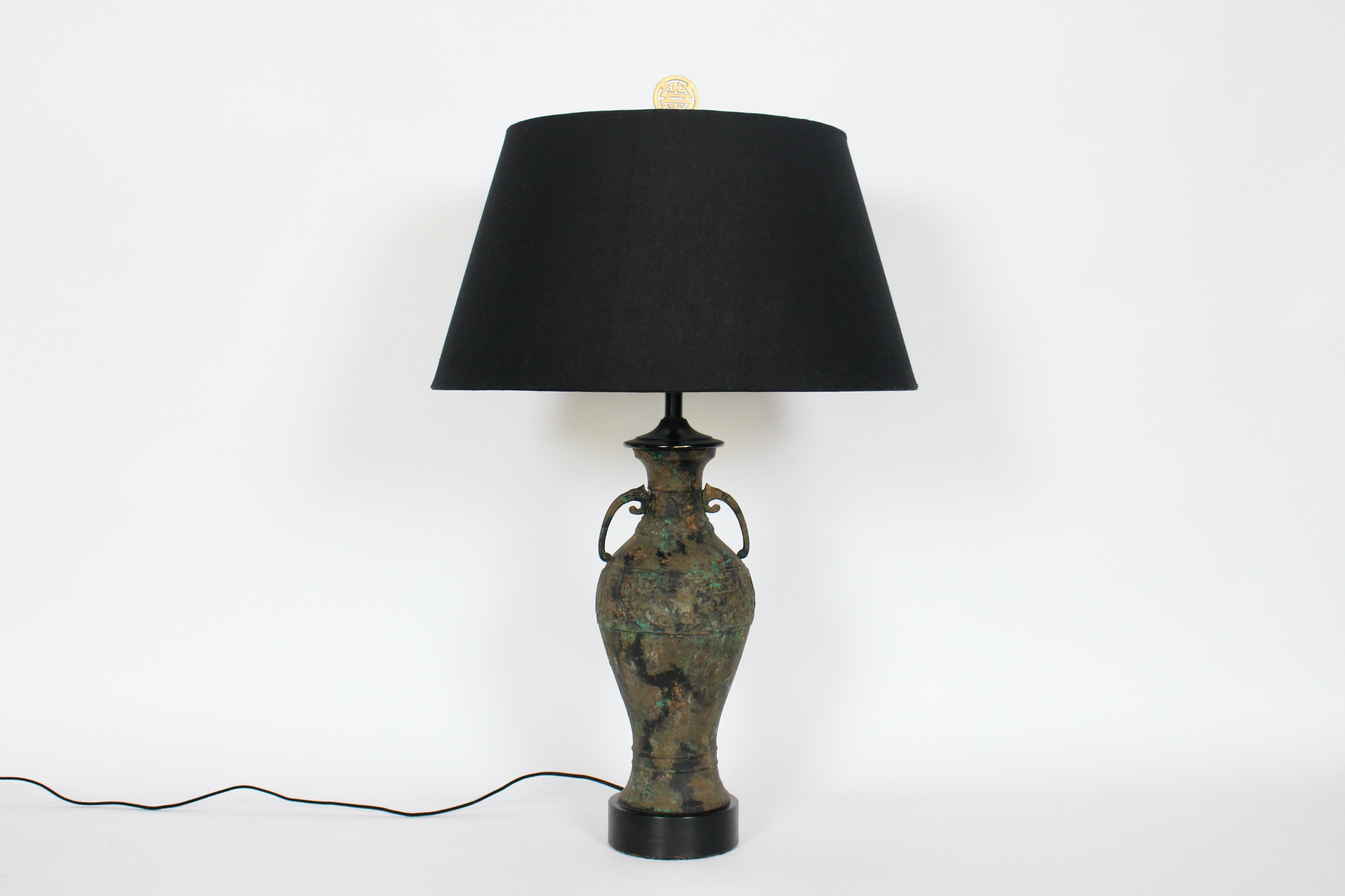 The Table Company attribue une lampe de table en bronze coulé de style asiatique ancien. Cette amphore à la forme élancée, influencée par l'Extrême-Orient, arbore des couleurs vert forêt, or, bronze, cuivre, vert-de-gris et laiton. Capuchon en