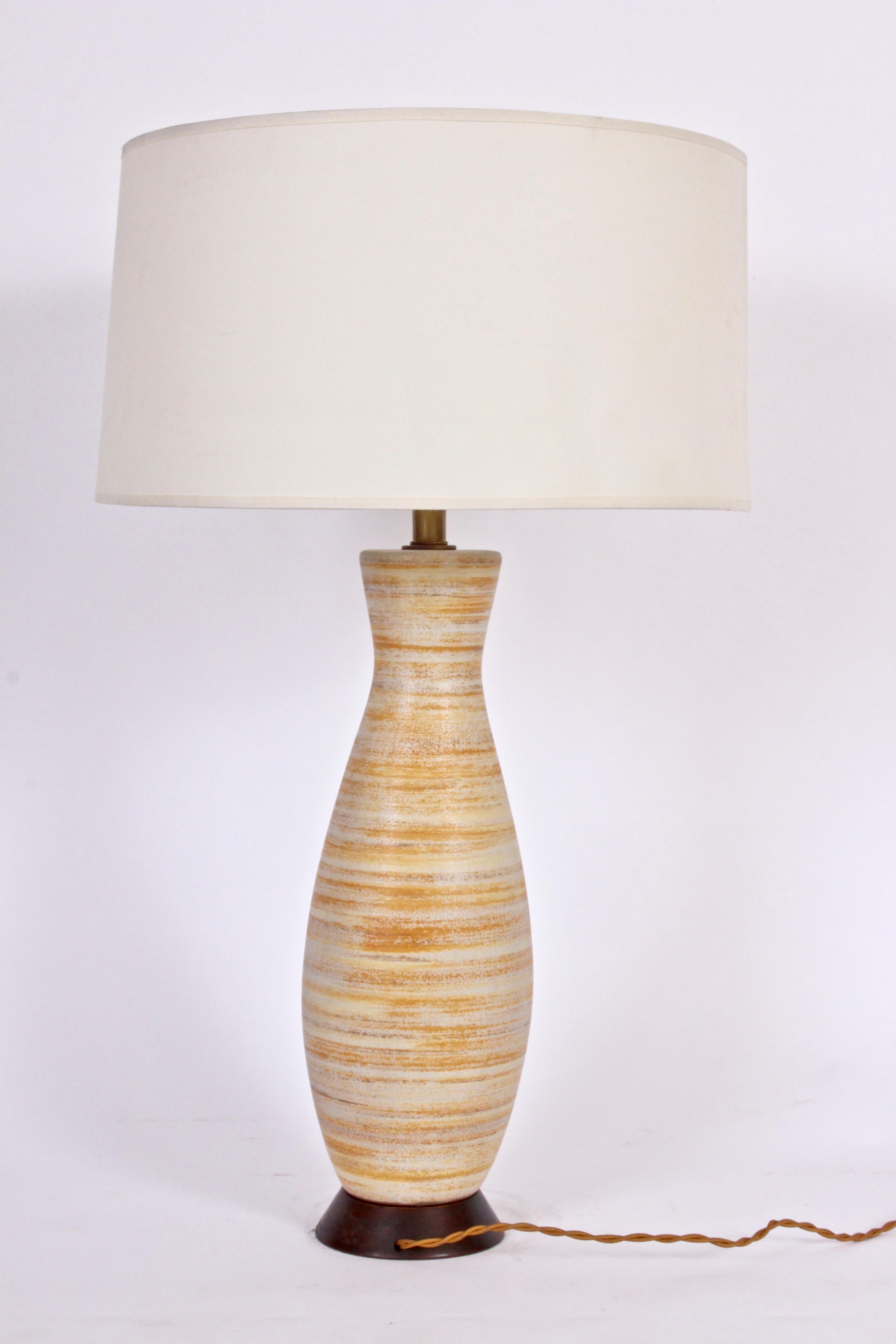 Substantial Lee Rosen for Design Technics hand-painted ceramic table lamp, 1950's. Featuring a hand crafted corseted classic DT pottery bottle form with hand-painted horizontal banding in subtle soft orange, pale yellow, brown, off-white, cream.