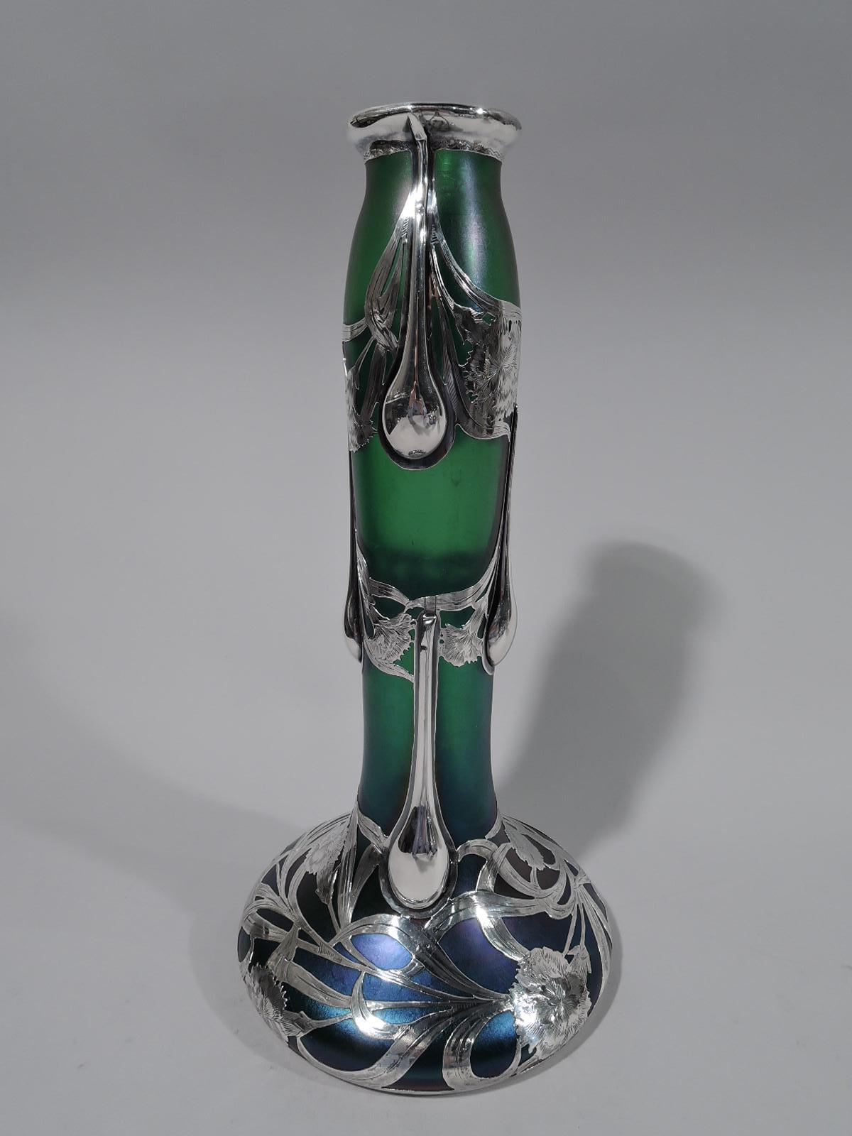 Beautiful Art Nouveau iridescent green glass vase by historic Loetz. Unusual form with tall cylindrical neck and bellied base. Engraved overlay in form of loose and entwined tendrils with flowerheads. Substantial teardrop drips on neck. Pontil mark.