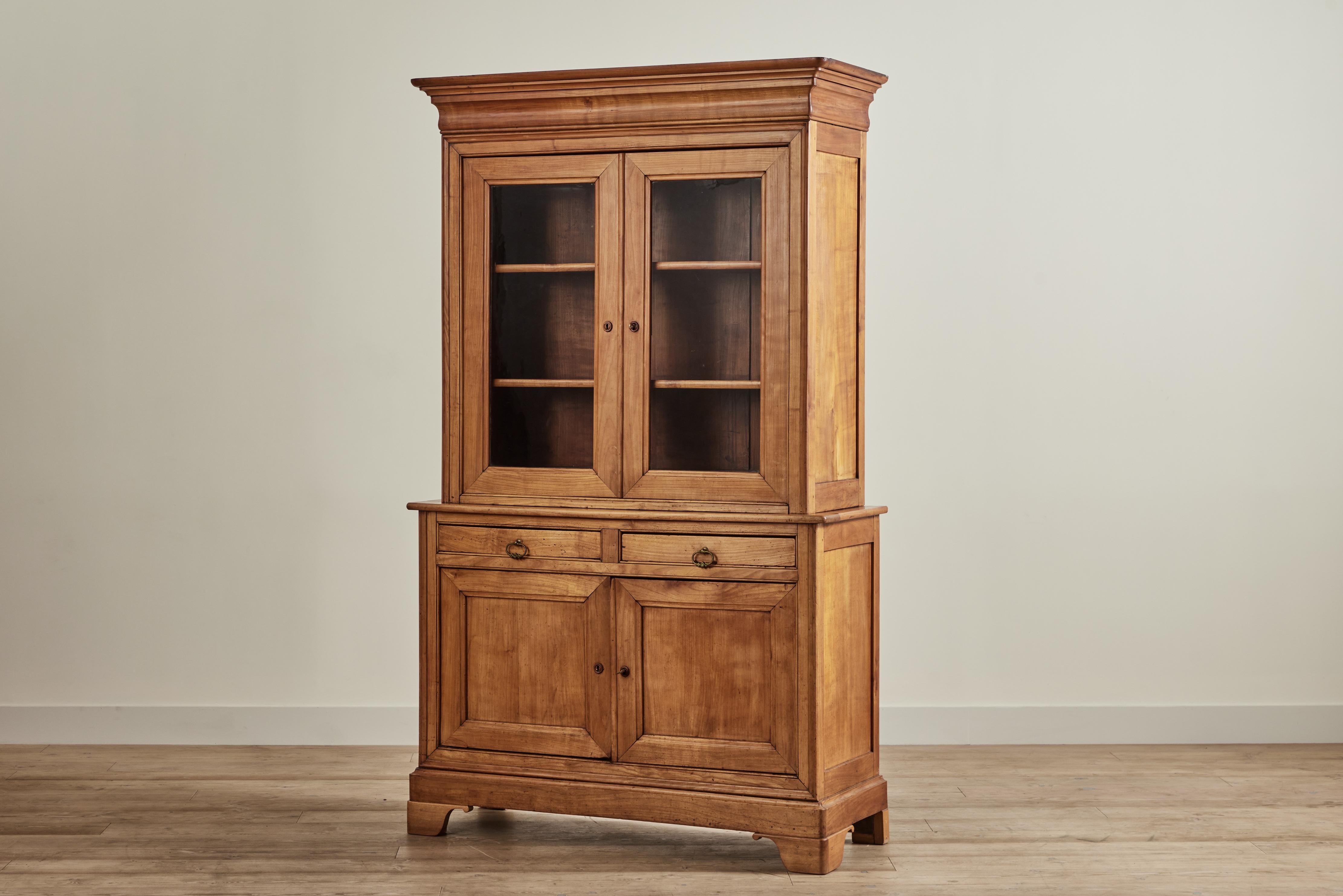 Nineteenth century Louis Philippe tall buffet cabinet from France with upper glass door cupboard, two central drawers, and two lower cupboards. Cabinet comes with a key and is in good vintage condition with wear that is consistent with age and use.