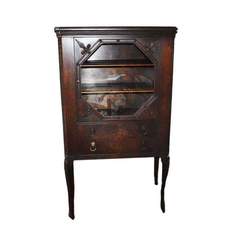 A fine tall antique china cabinet of mahogany featuring two drawers and a glass door. A wonderful piece for use as a china display cabinet, linen storage, curio hutch, or tallboy. This lovely piece features tall curled legs with claw feet which will