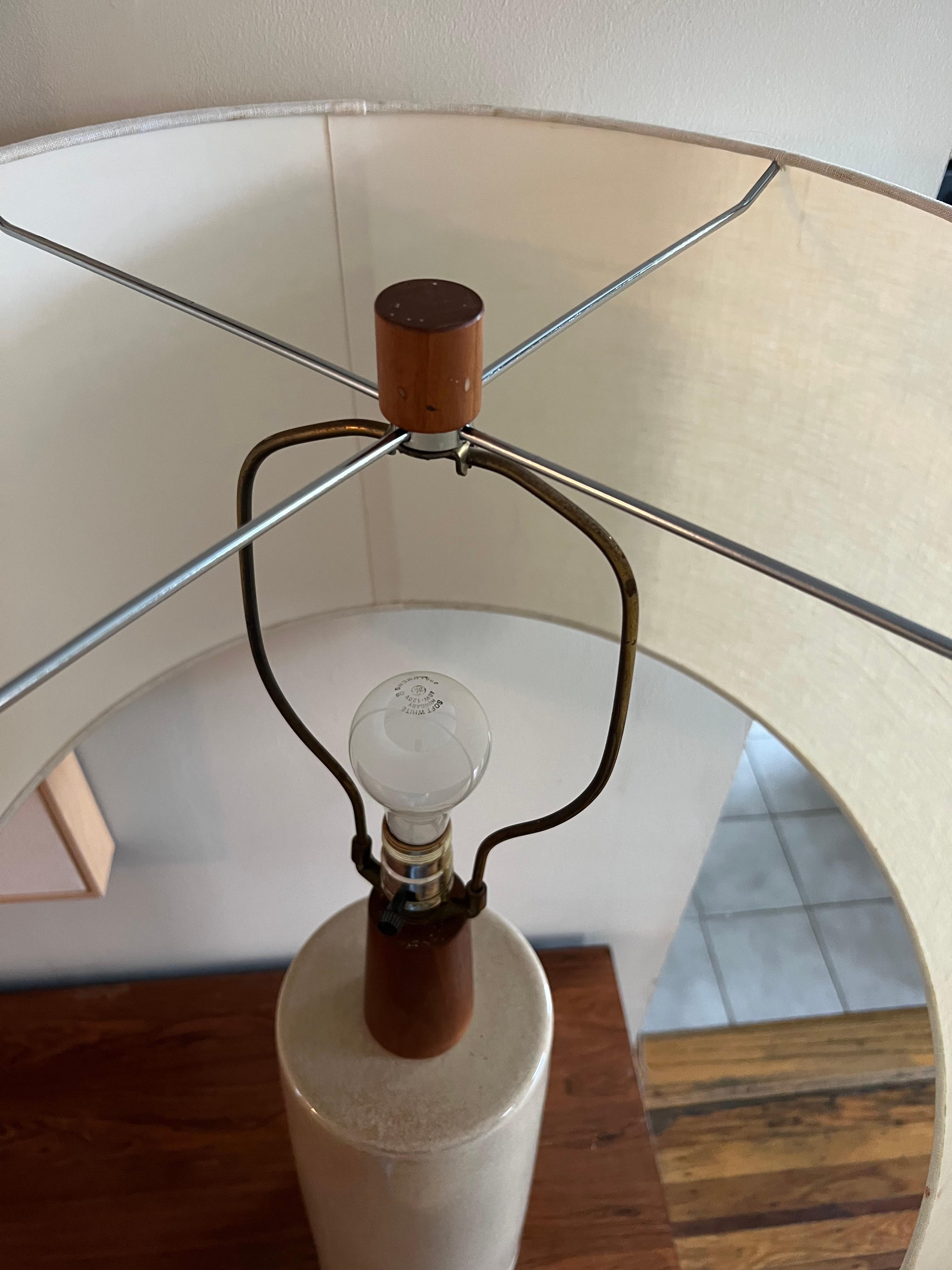 Classic from ceramic table lamp by husband and wife team, Gordon and Jane Martz. Walnut stem and finial. Signed at back. Natural linen shade is 20