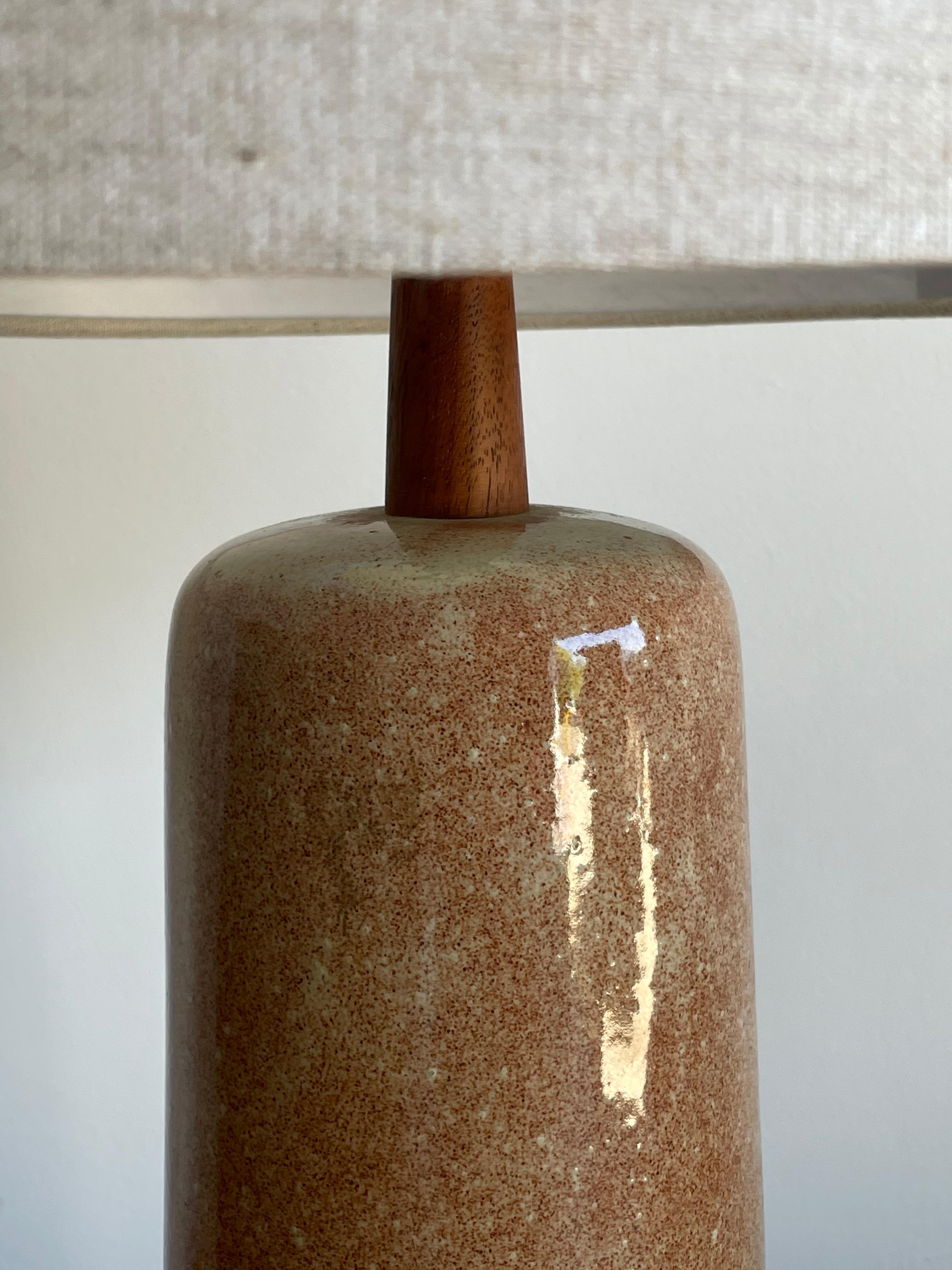 Unusual tall ceramic table lamp by famed ceramicist duo Jane and Gordon Martz for Marshall Studios. Wonderful rose/ blush color ceramic body accented with a walnut neck and finial. 

Measures: 
Overall 
26.5