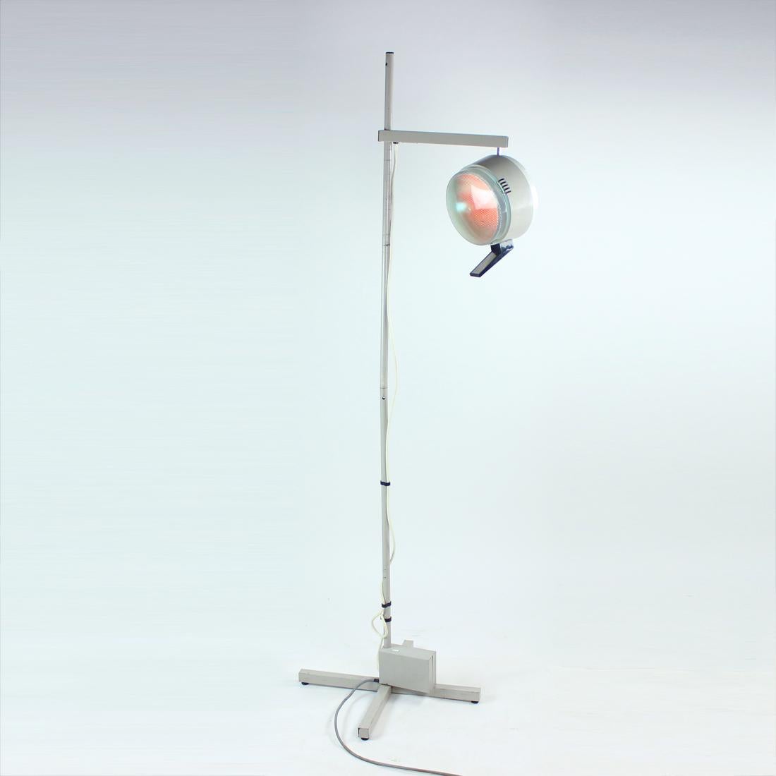 Wow, what a find! This is an original floor lamp used by a medical doctor since 1960s. The lamp stands on a metal base with gray colored steel. The actual light is held by a metal arm. The light is easy to adjust to any postion. There are two