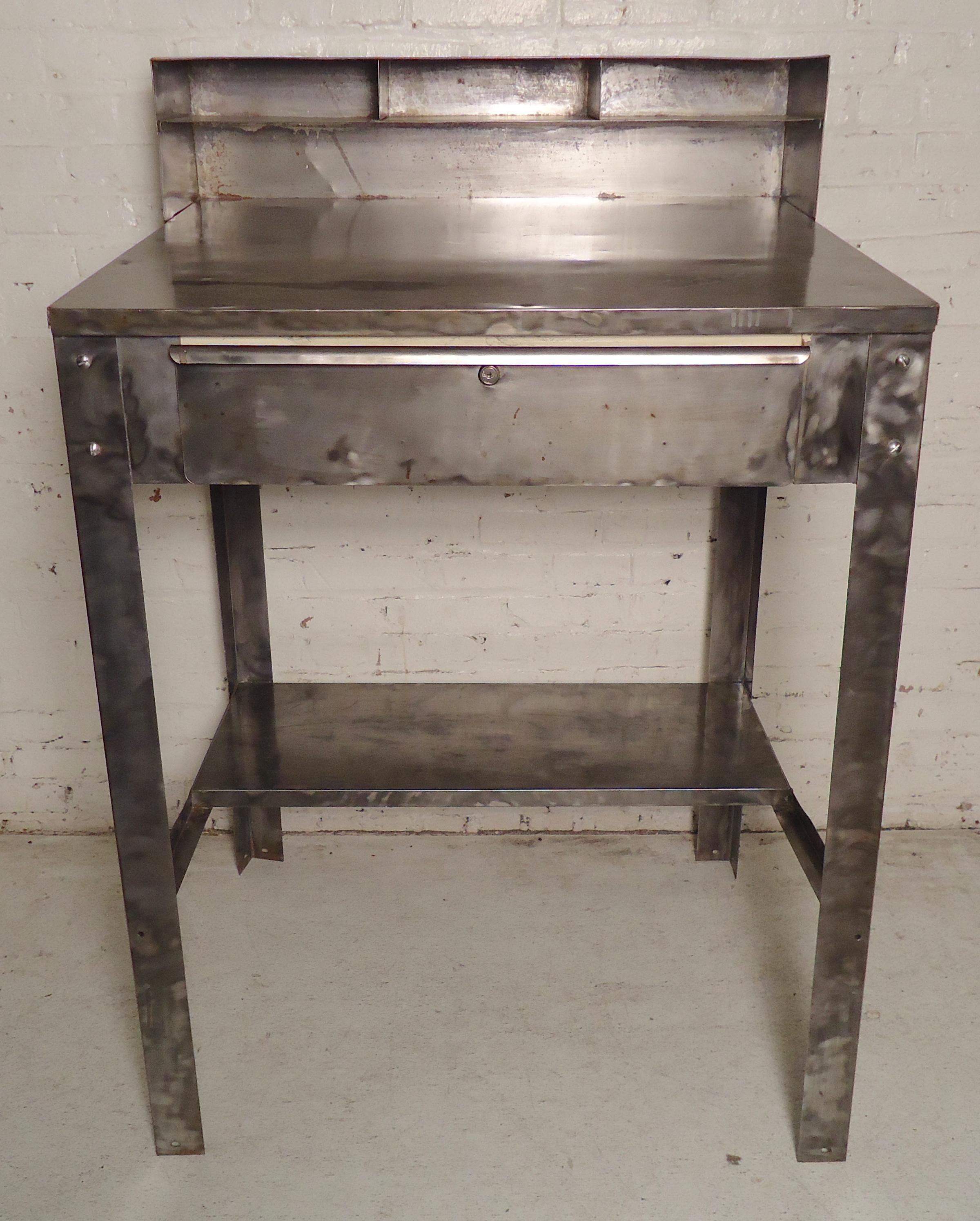 Industrial metal drafting table or restaurant serving station. Refinished in a bare metal style. Slanted top, back storage and drawer.
(Please confirm item location - NY or NJ - with dealer).
 