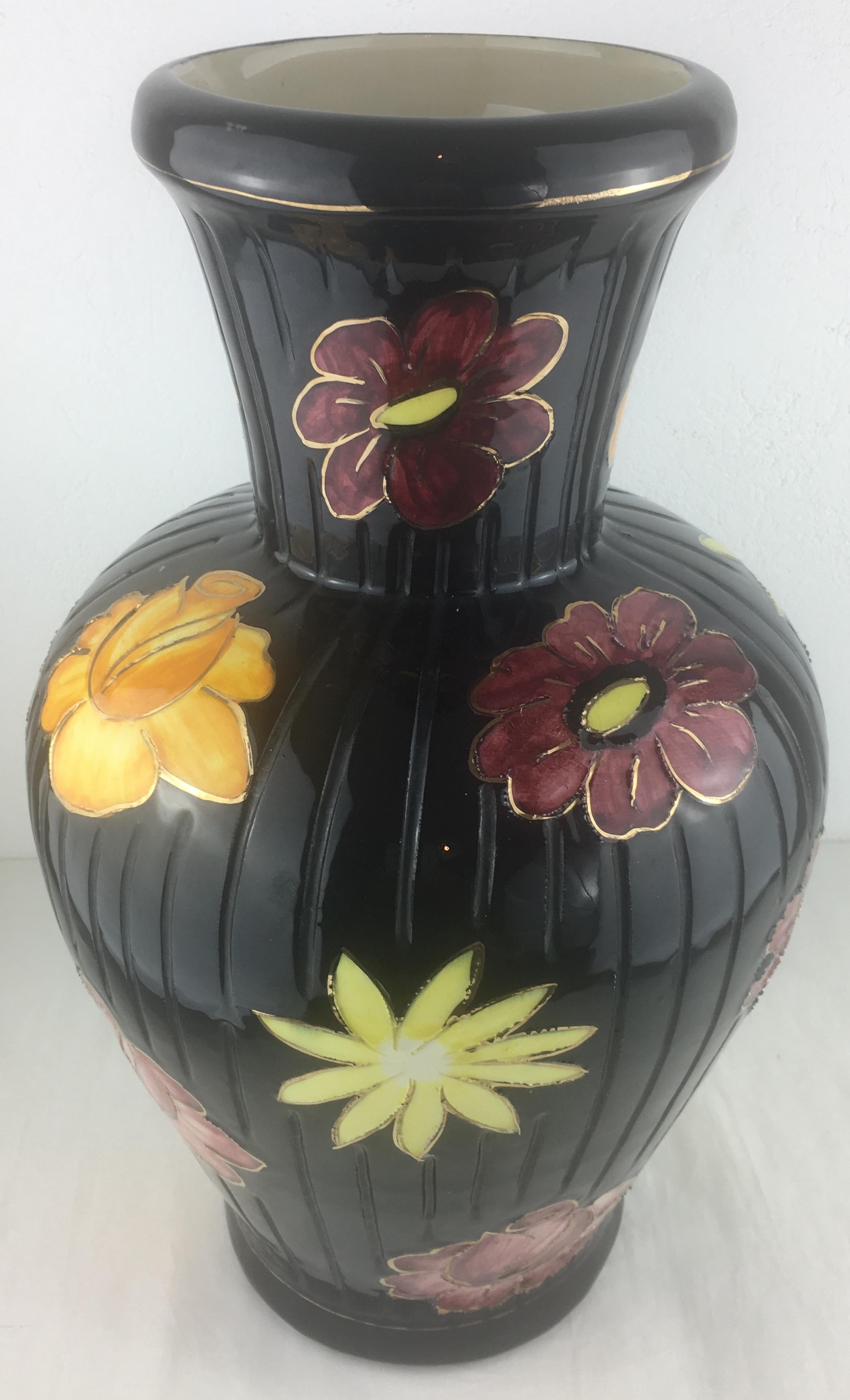 A fine midcentury ceramic vase from Vallauris, France. 
Handcrafted with great precision. The black background is adorned with multicolored flowers, predominantly red and yellow, making this piece very pleasing to the eye. Glazed. 

In perfect