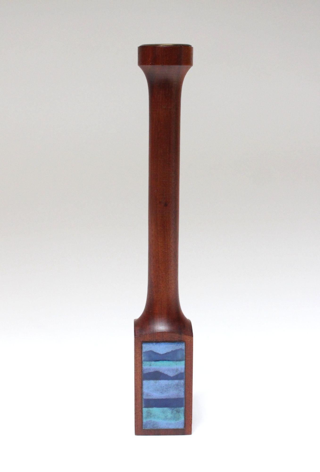 Large candlestick/votive holder by enamelist, Ernest Sohn, in solid, deeply sculpted walnut with enamel panel decoration (ca. 1960s, USA).
Enamel boasts beautiful blue and aqua tones contrasting nicely with the rich walnut tone and brass