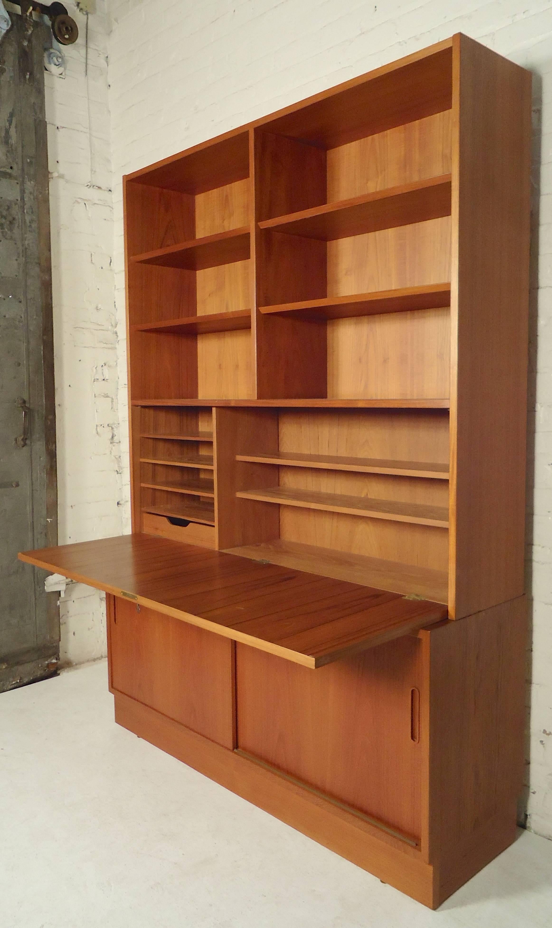 Large Danish cabinet in teak grain with drop down desk and bottom storage space. The top unit rests on the cabinet. Features ample storage and locking desk.

(Please confirm item location, NY or NJ, with dealer).
 