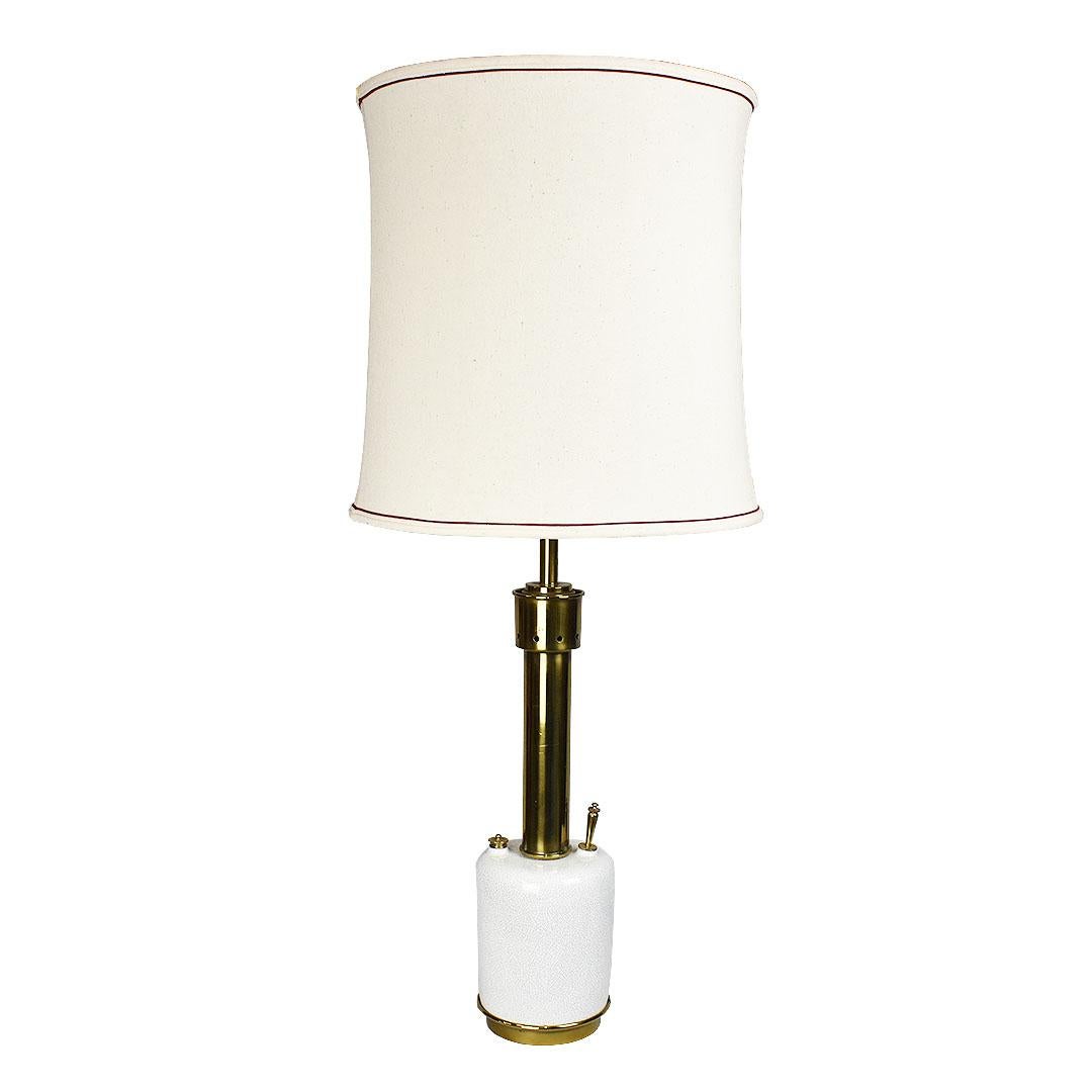 A tall ceramic and brass torchère style table lamp by Stiffel. A rare find, this circular lamp with white crackle glaze, has long been a difficult find for Stiffel lovers. 

The round body of the lamp is created from ceramic and is crackle glazed