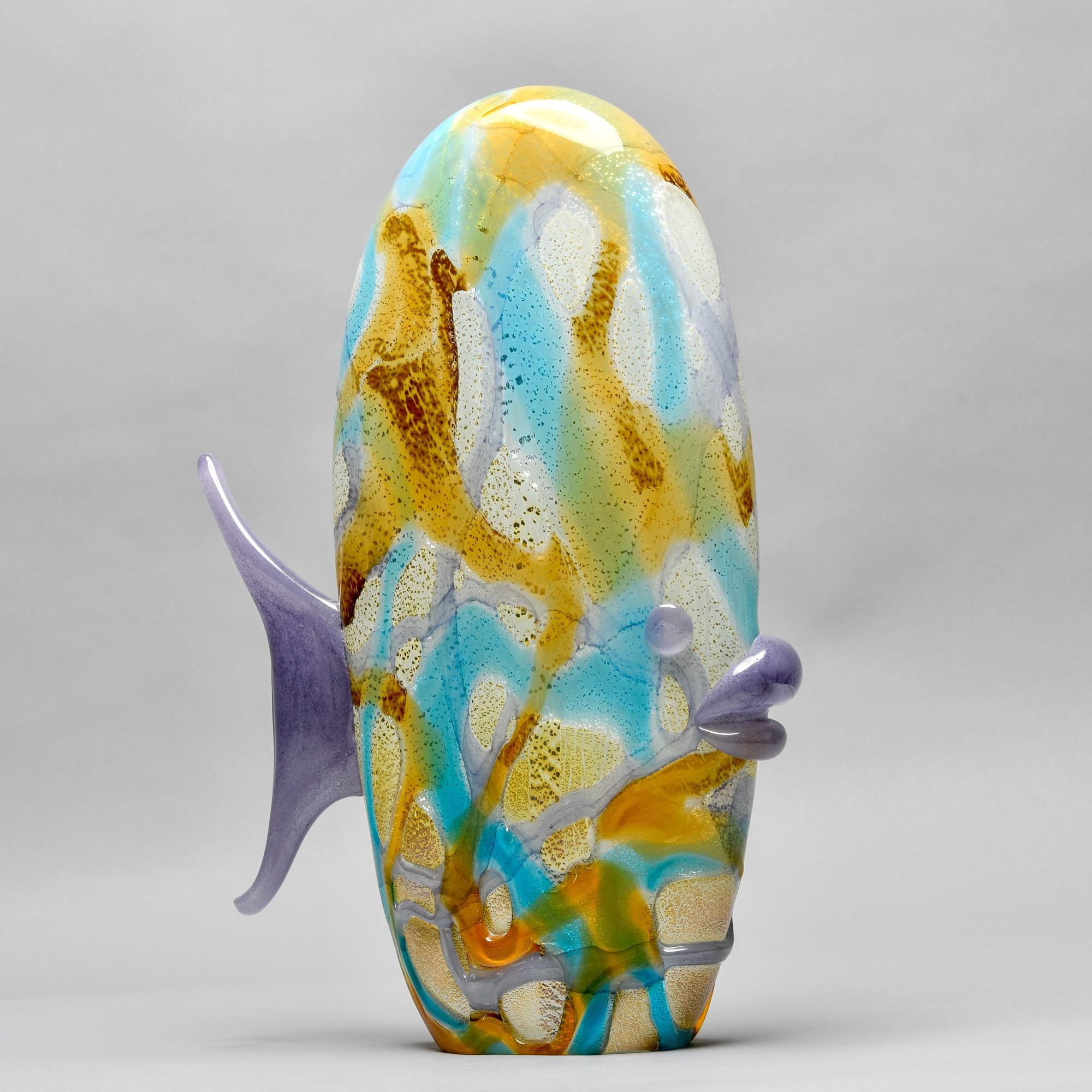 Circa 1980s Murano glass fish is over 14” tall. Glass is streaked with amber and blue tones and has applied lilac glass tail, mouth and eyes. Unknown Murano maker. No flaws or repairs found.