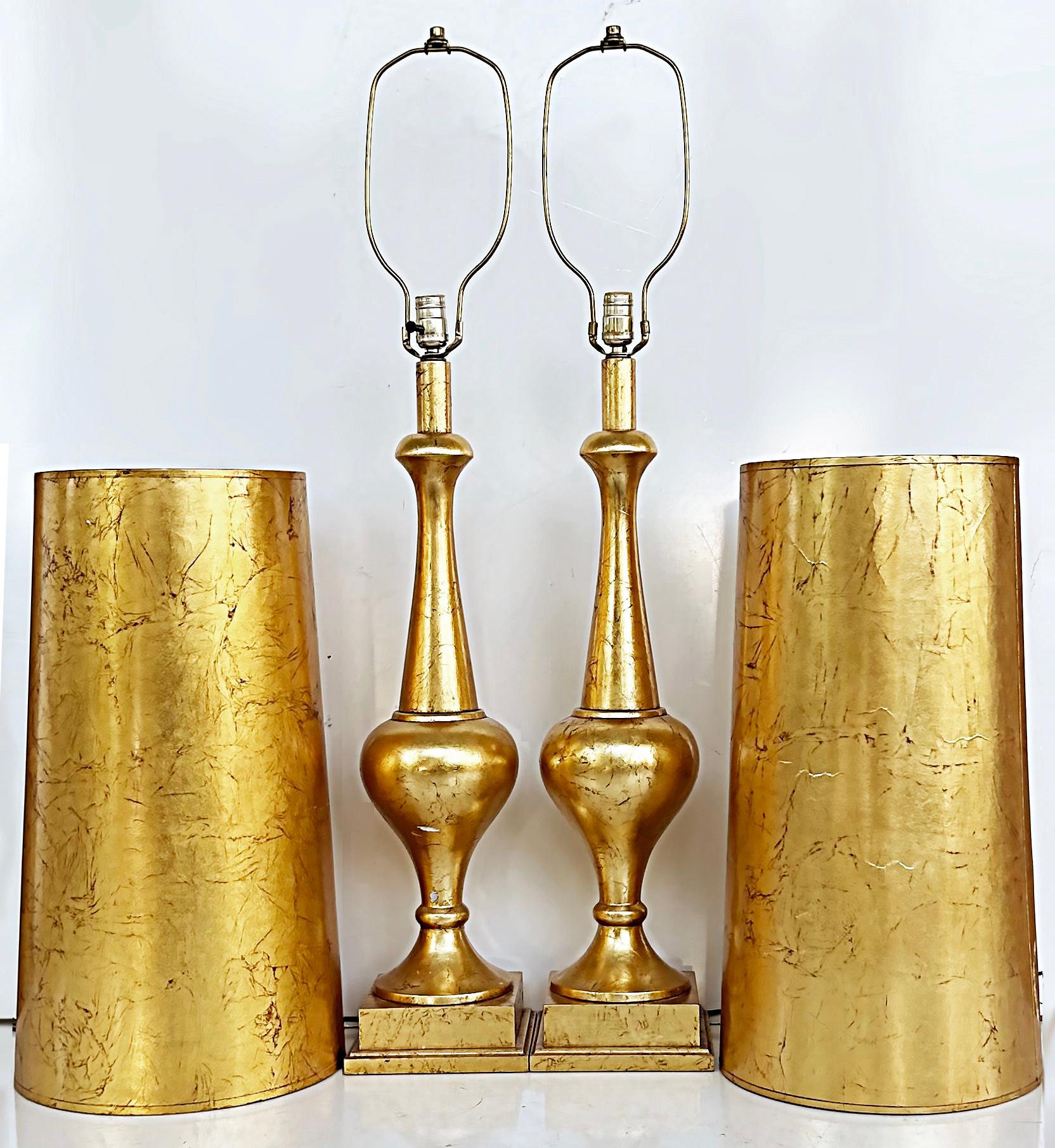 Midcentury Pair Italian Tall Gold Leaf Turned Wood Table Lamps with Gilt Shades

Offered for sale is a tall pair of turned wood table lamps that had previously been gold leaf gilt and fitted with slender gold leaf gilt shades. The lamps have a