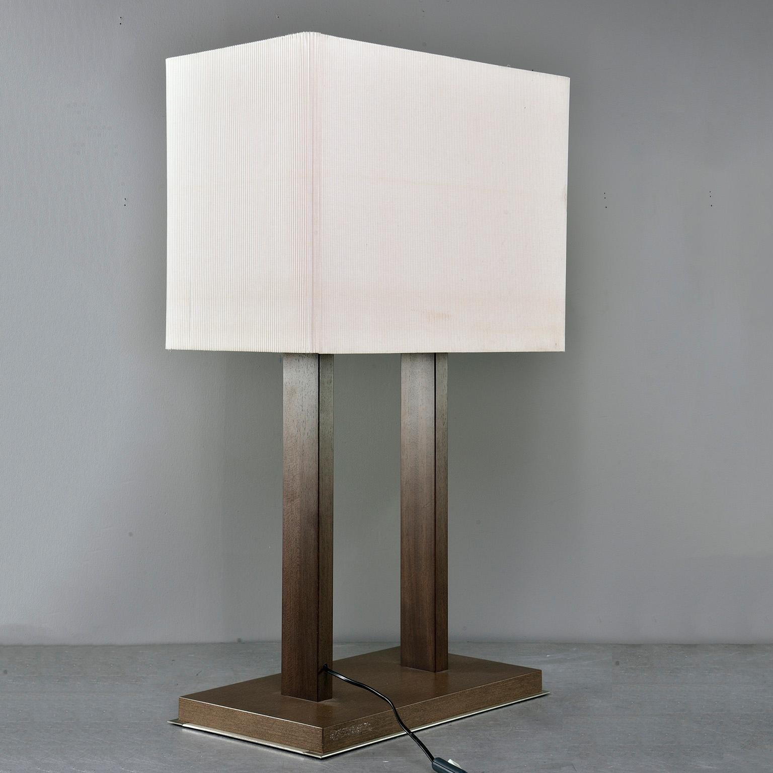 Tall table lamp has a base of walnut layered over brushed steel with walnut supports and a tightly pleated rectangular shade, circa 1970s. Unknown maker. Found in Italy. New wiring for US electrical standards.

Measures: Shade only: 15.5” H x 20”