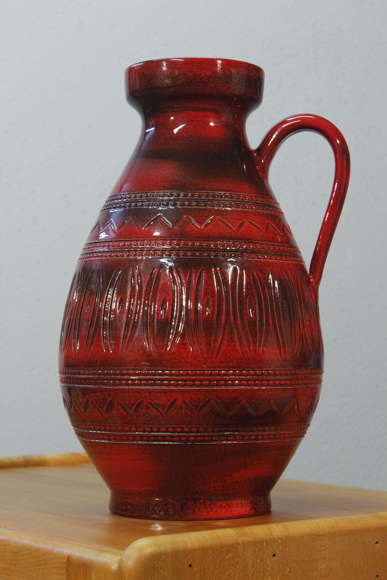 Ilkra Edel Keramik grand vase de sol avec anse, avec des motifs scarifiés et un émail rouge et noir profond. 

En très bon état général