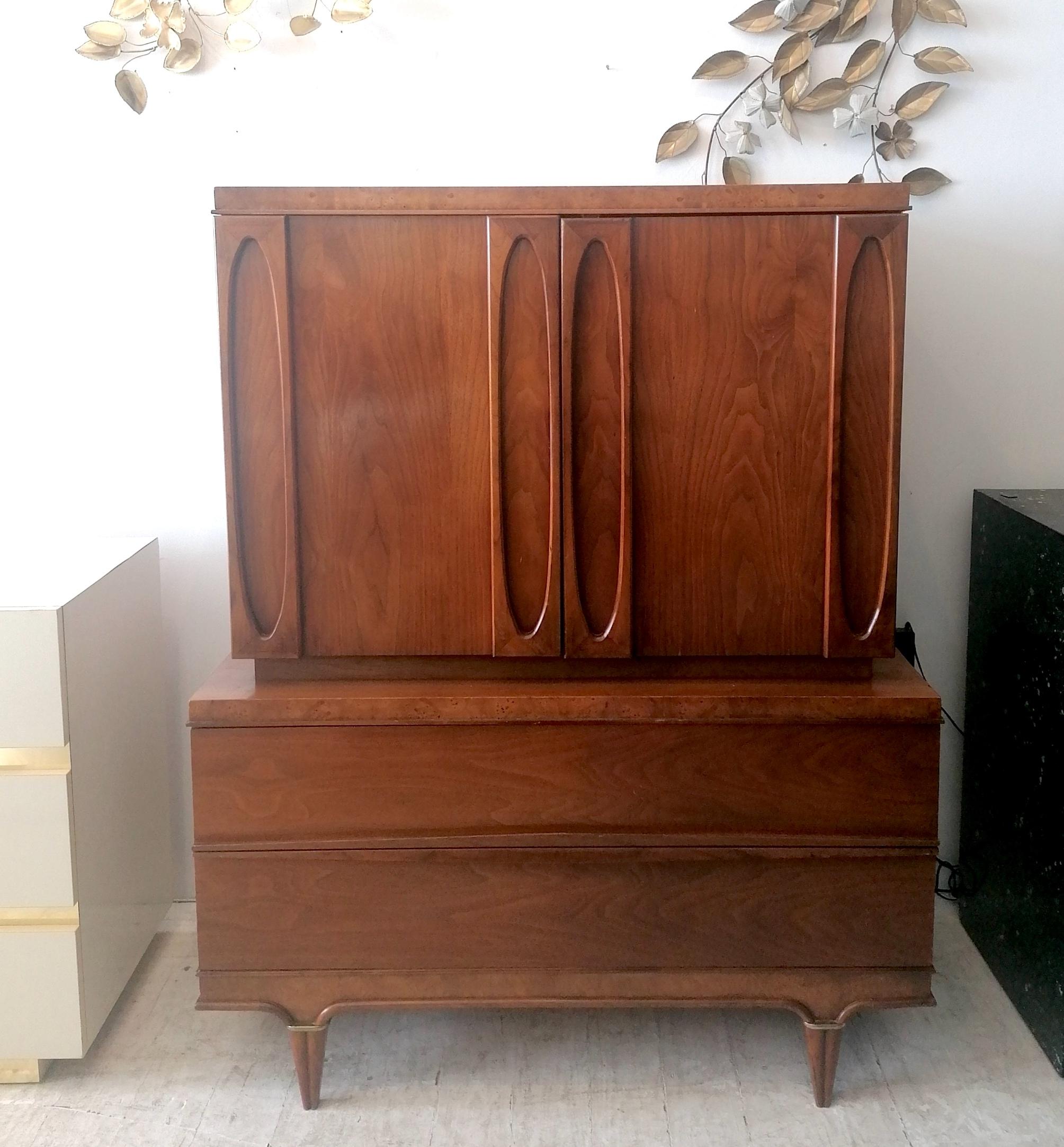 Tall midcentury cabinet by 'American of Martinsville' USA 1960s. Walnut and burr elm, with gilt metal trim on legs
A few little bits of wear (there's a small chip on back edge trim, see last pic) but looks great overall.

Dimensions: width at base