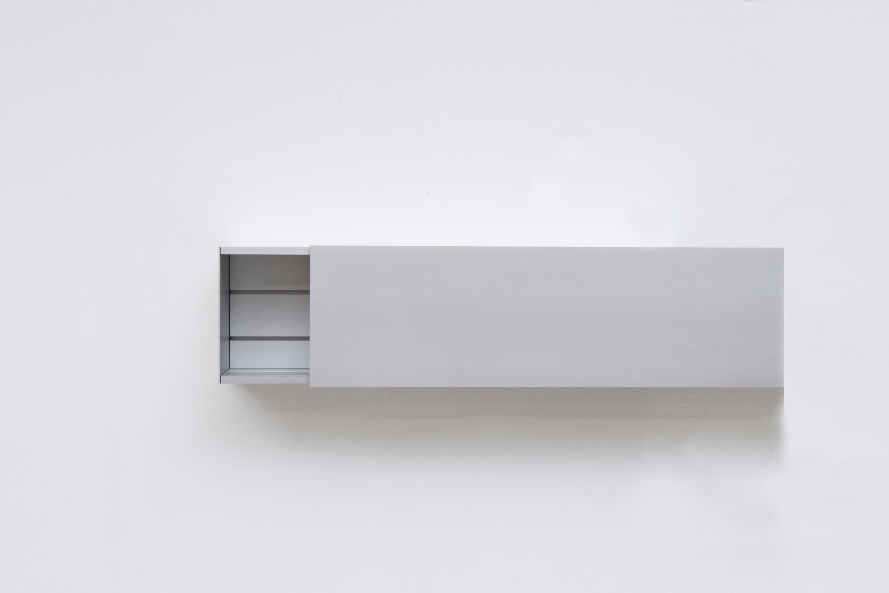 Sleek Minimalist Pastoe Linear aluminum cabinet by Shigeru Uchida. Minimalist wallmount shelving with sliding door. In original condition with normal wear. One Longer and Thinner Version Available, Listed Separately (LU922419984432).