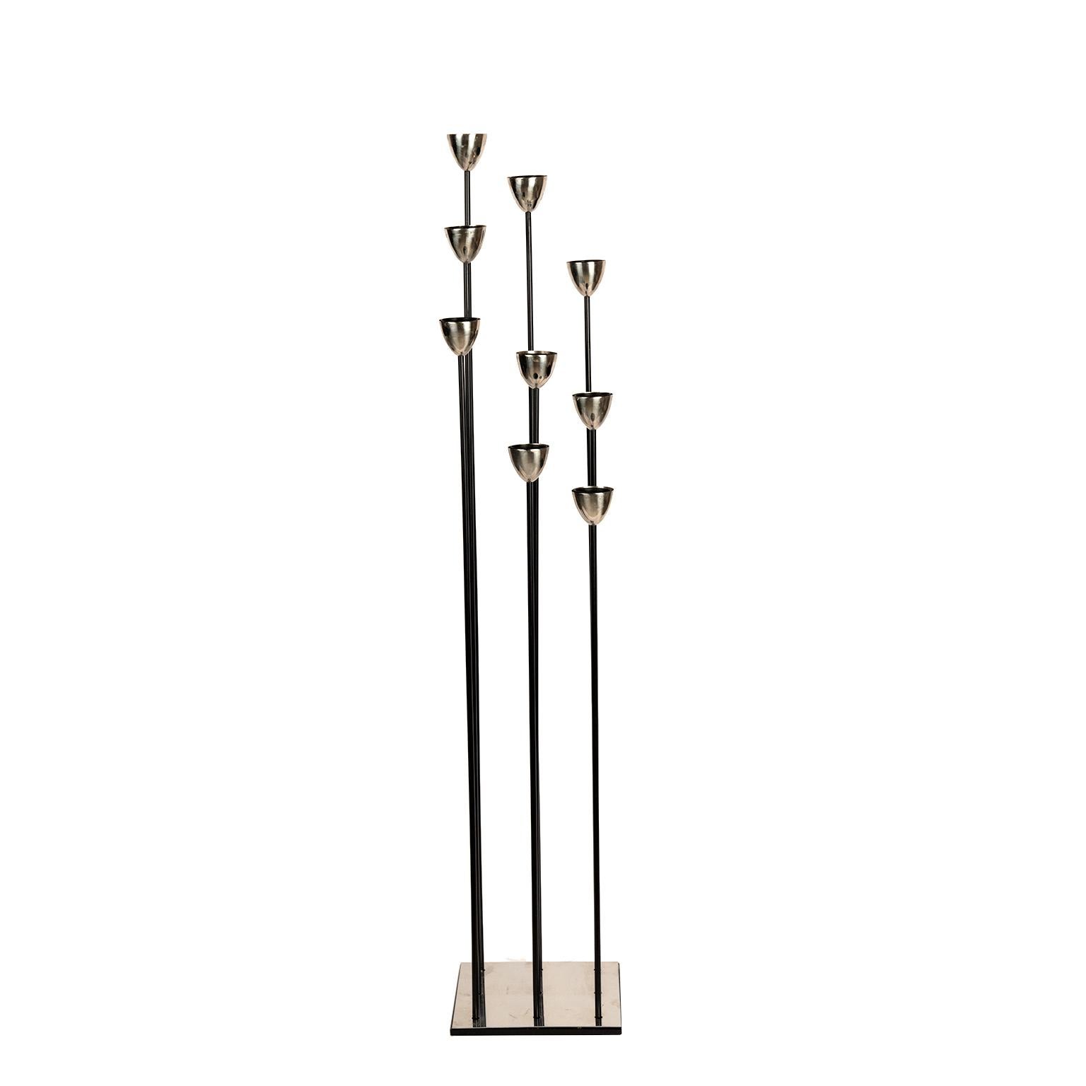 This unique tall eight light candelabra is as made of polished steel and black painted metal. It may sit on the floor or put it on a plinth and it becomes a piece of art/sculpture reminiscent of the brutalist sculptures of Harry Bertoia