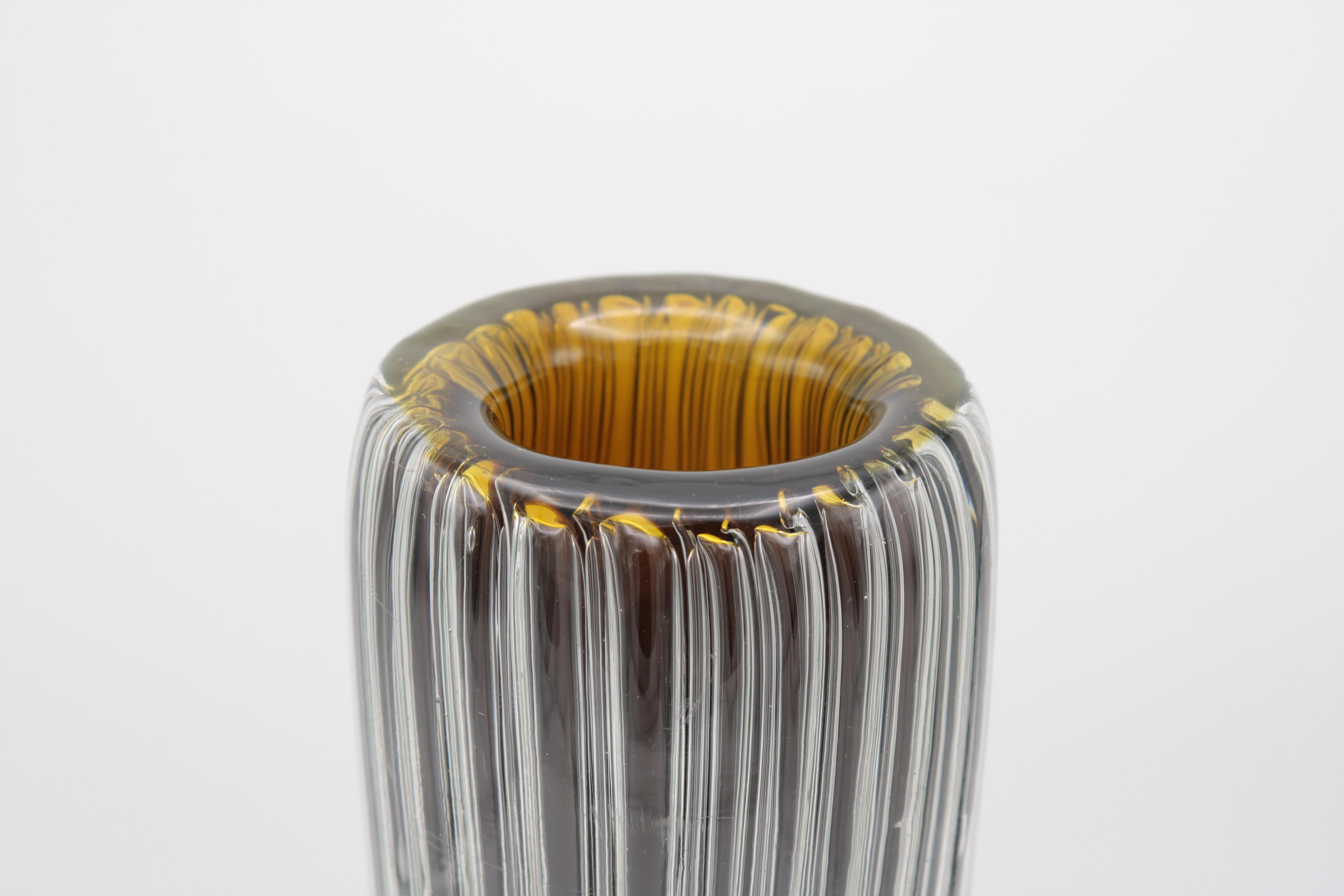 A tall Murano art glass vase by Paolo Venini.
Clear glass with a layer of combed air bubbles
and an inner layer of brown and green.
Engraved: Venini Italia.
