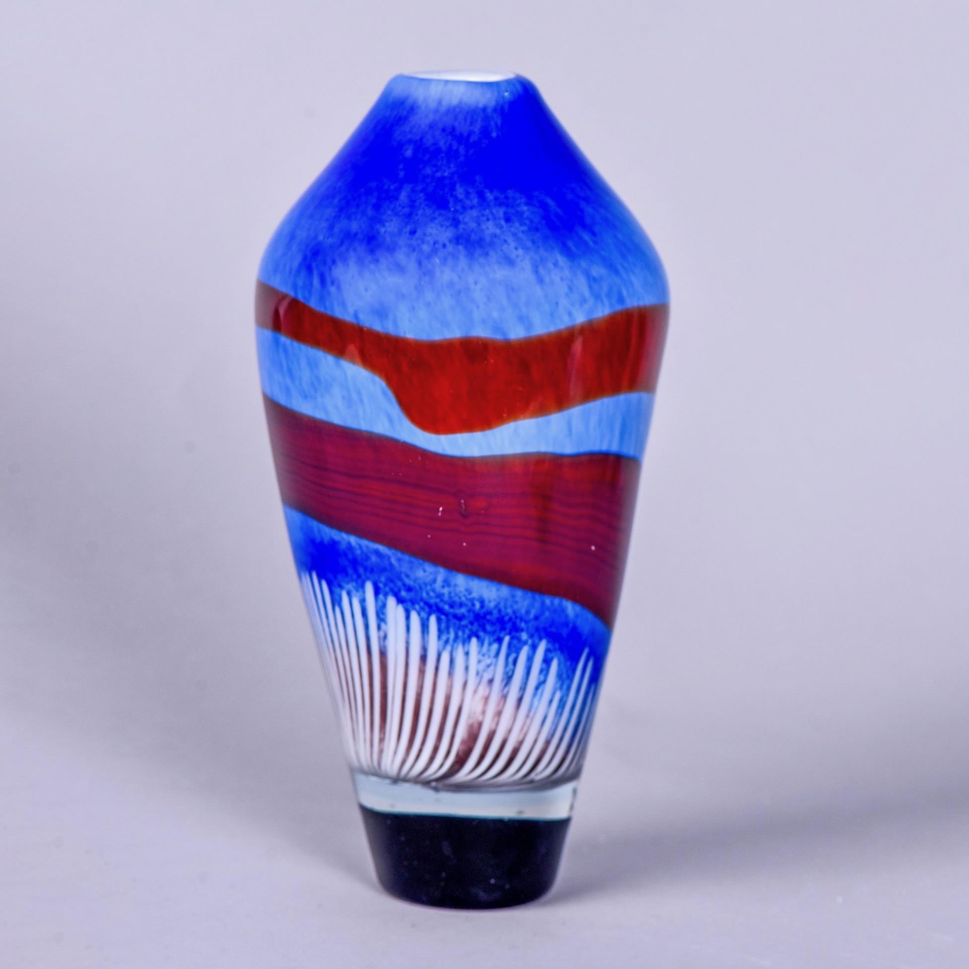 Just under a foot high, this Murano glass vase in azure blue has a deep blue base, wavy bands of burgundy red and white accents. Unknown Murano maker.