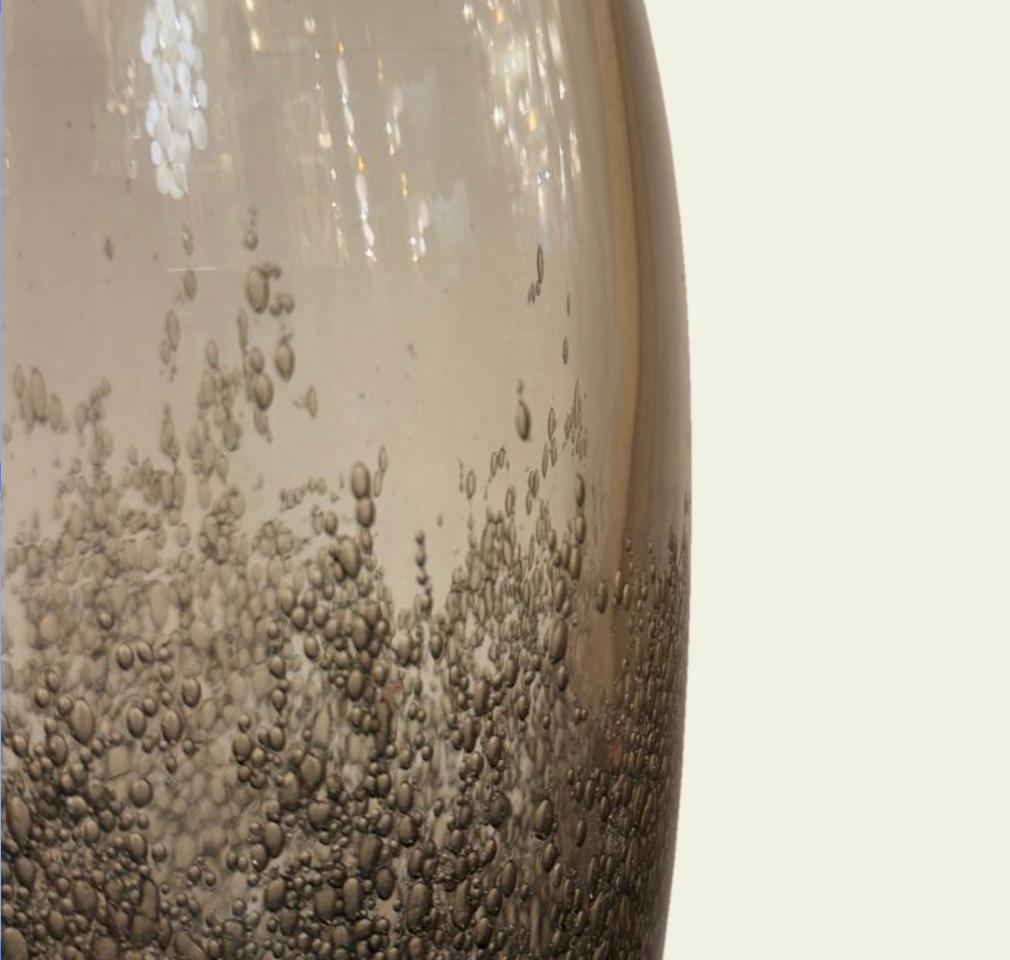 Mit ihrer rauchigen, grauen Farbe und der sprudelnden Textur bringt diese Glasvase die Eleganz venezianischer Handwerkskunst in jeden Raum. Diese Vase wurde in Murano in der traditionellen Pulegoso-Technik mundgeblasen und weist eine dichte