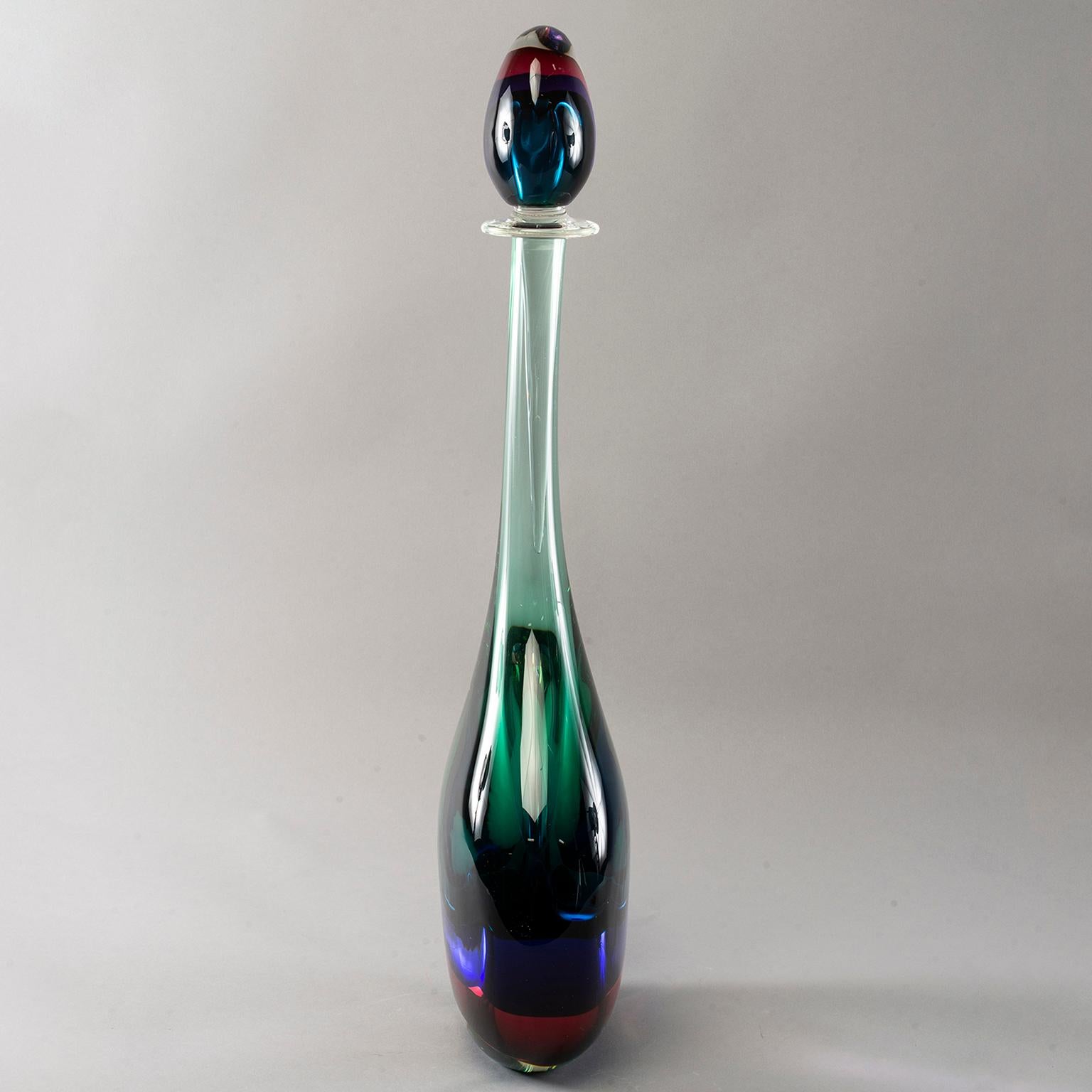 Monumental Murano glass Sommerso style bottle with perfume style stopper. Clear outer layer of glass with magenta, sapphire and emerald layers of color in both bottle and stopper. New, with no flaws found. Unknown maker. We import these new from