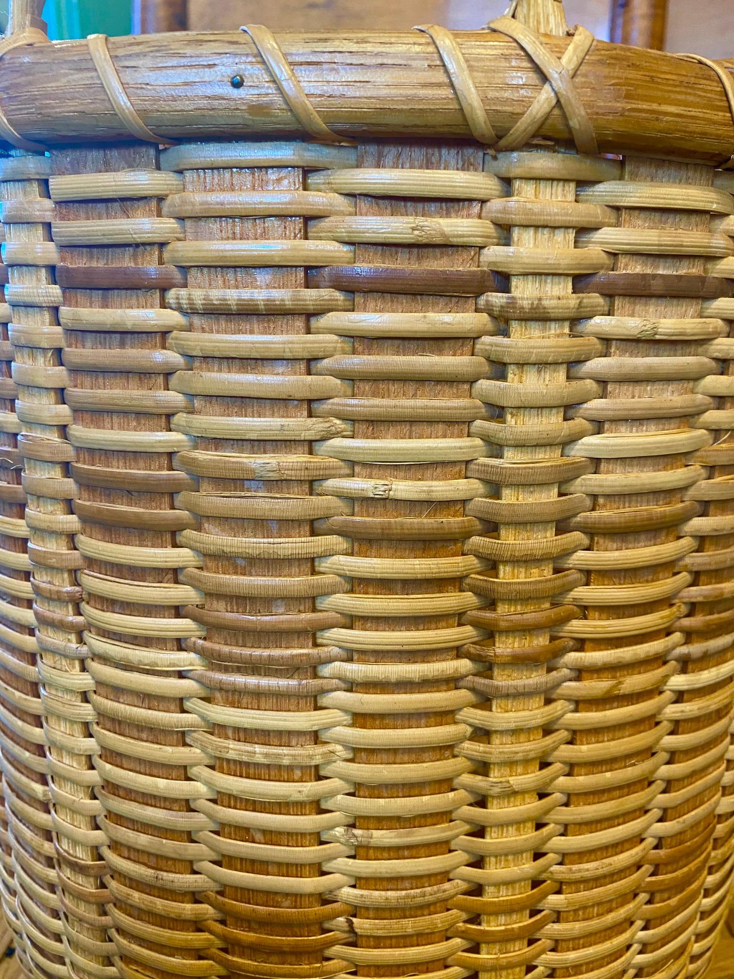 Vintage tall Nantucket round open basket by Arthur Martin, (Massachusetts: 1930 - 2000), circa 1990, featuring his characteristic wide oak staves and oak bottom. This very large basket is unusual in having the handles continued as staves all the way