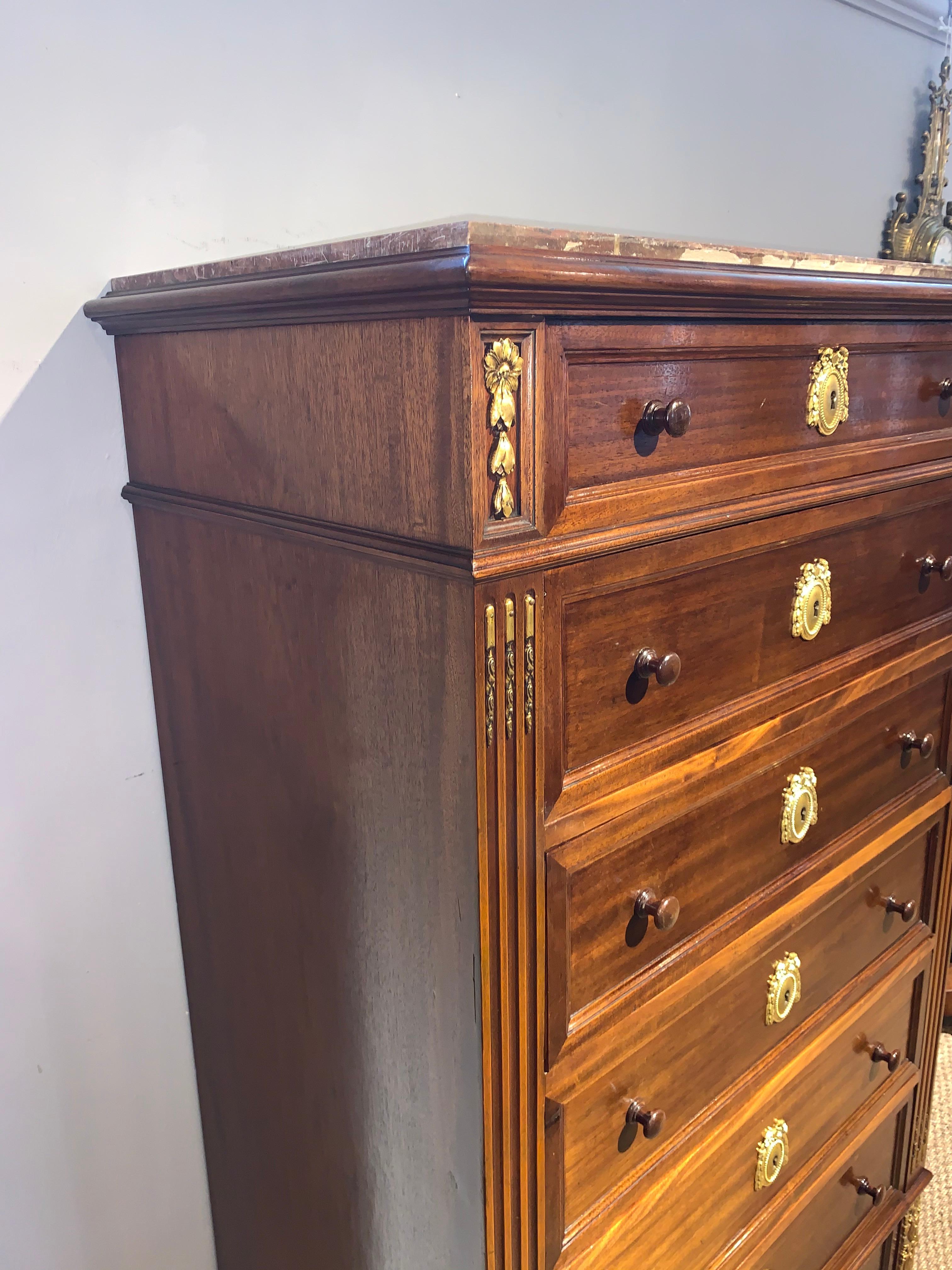 Great early 20th century tall narrow chest of 7 drawers, known as a semainier, drawer for each day of the week

This piece is made of solid walnut with original ormolu mounts, supplied with working locks and a key, rouge marble top 

Having been
