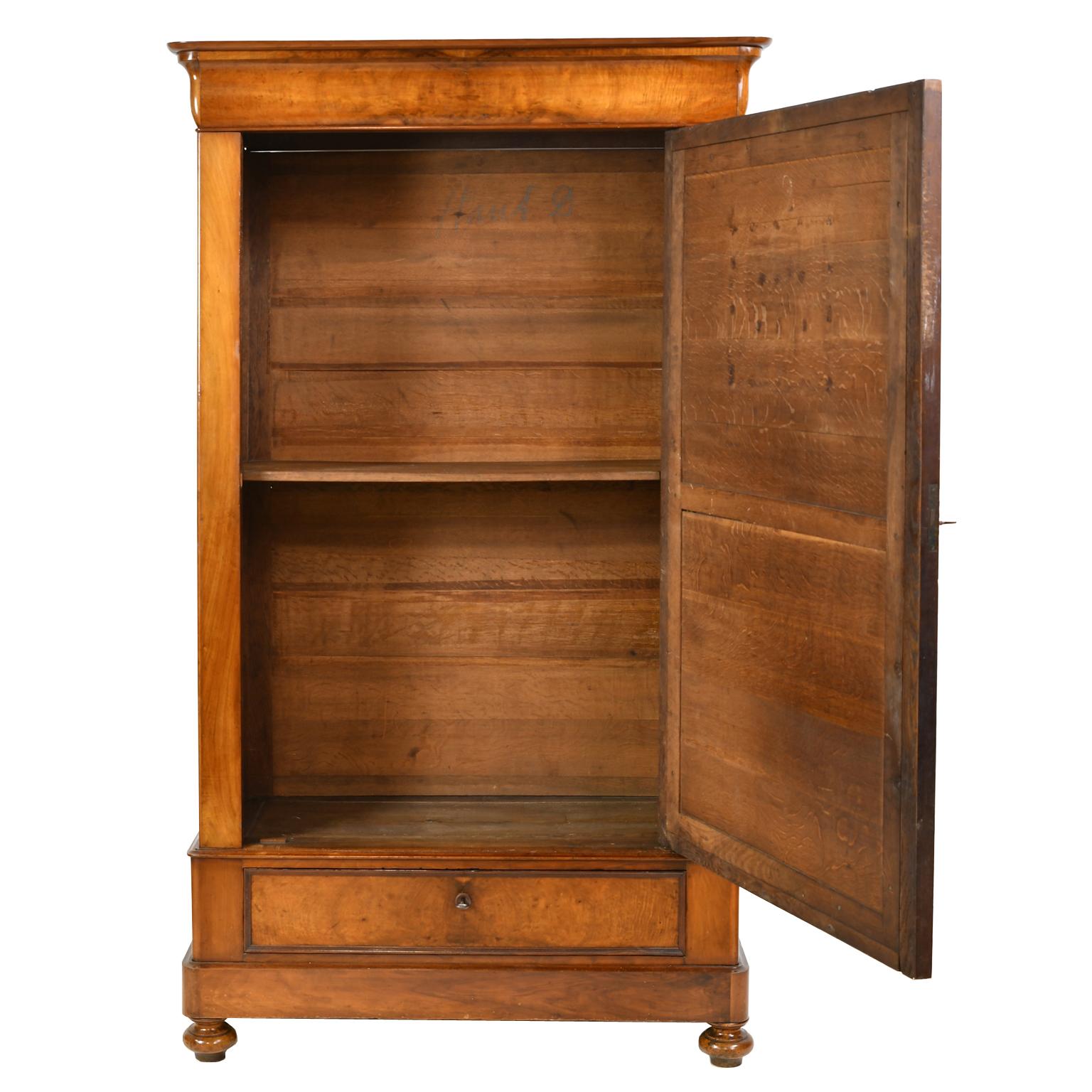 An exquisite French Louis Philippe armoire in walnut with one mirrored-door and bottom drawer. Interior offers one adjustable shelf (others may be added upon request). The grain of the walnut has some beautiful figuring and the color is a medium