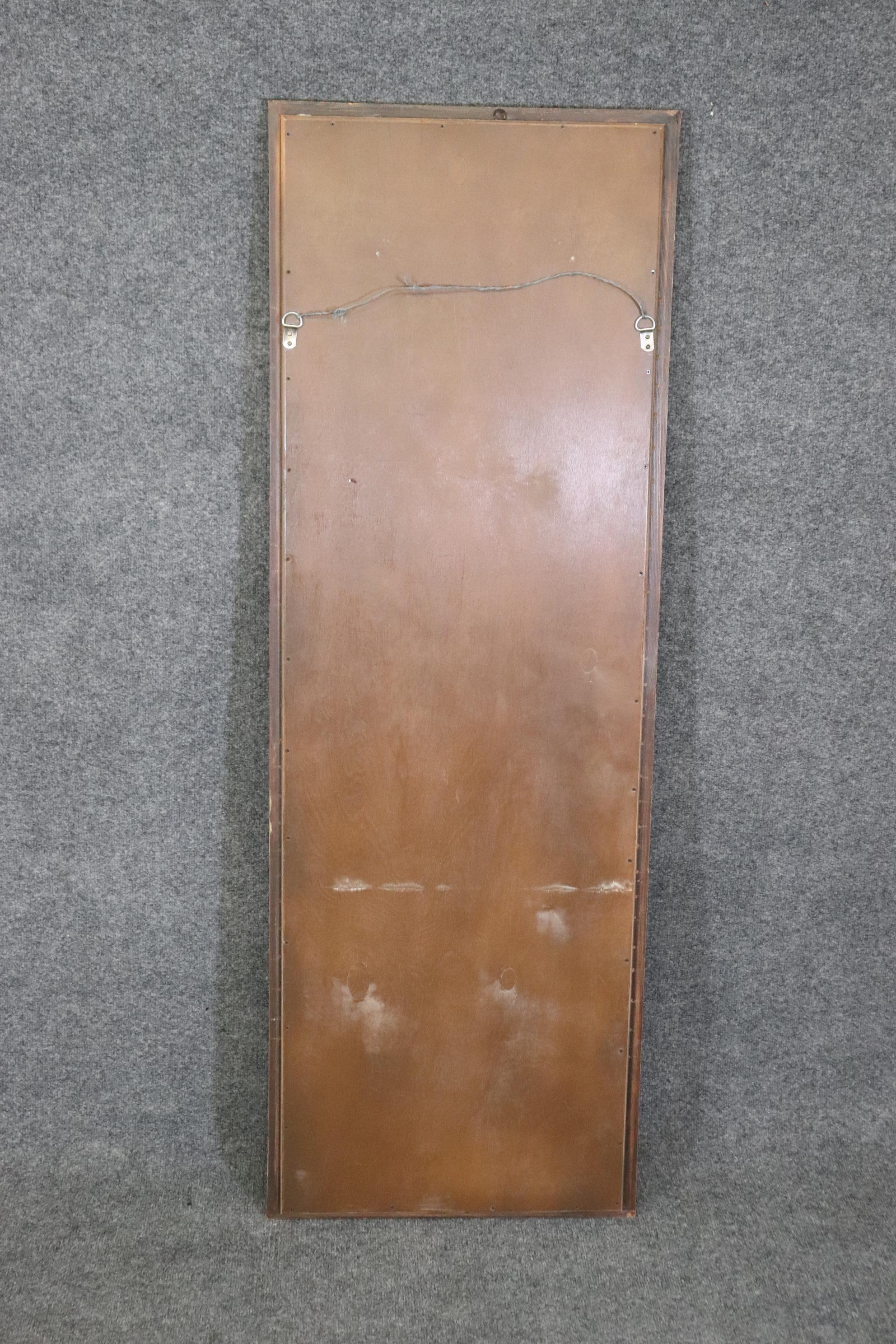 This is a gorgeous narrow mirror that can be hung vertically or horizontally. The mirror is in good condition and has no major signs of wear or damage. The mirror measures 58.25 tall x 20 inches wide x 2 inches thick. The mirror dates to the 1940s. 