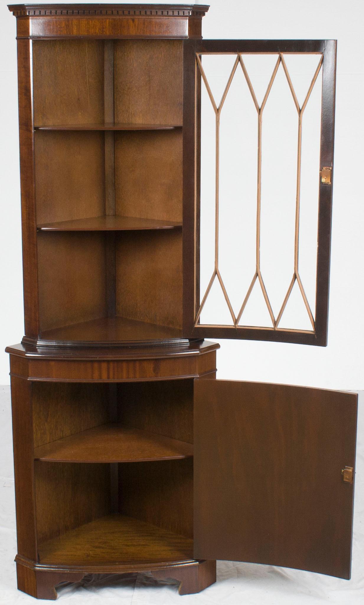 This elegant bow front corner cabinet was crafted in England around the year 1960. Today it remains as lovely as ever, with rich mahogany, bracket feet, and beautifully adorned locking doors.

The bow front corner cabinet is such a lovely design