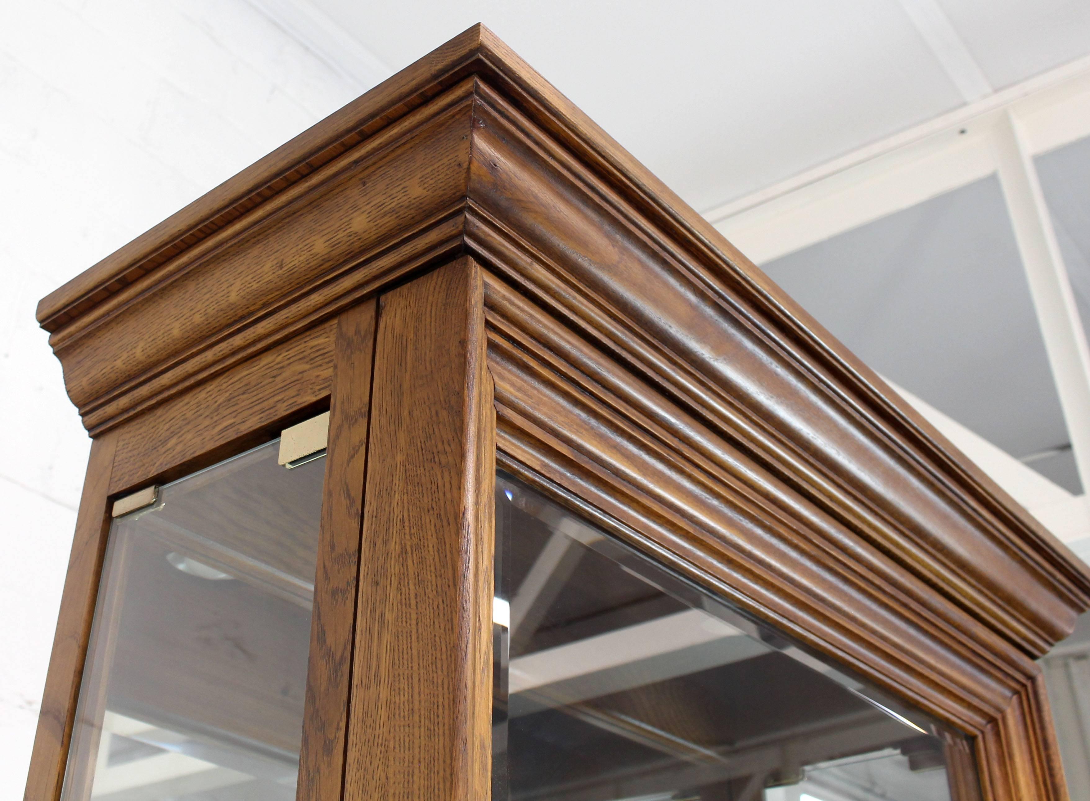 Modern oak thick beveled glass display curio cabinet with side excess.